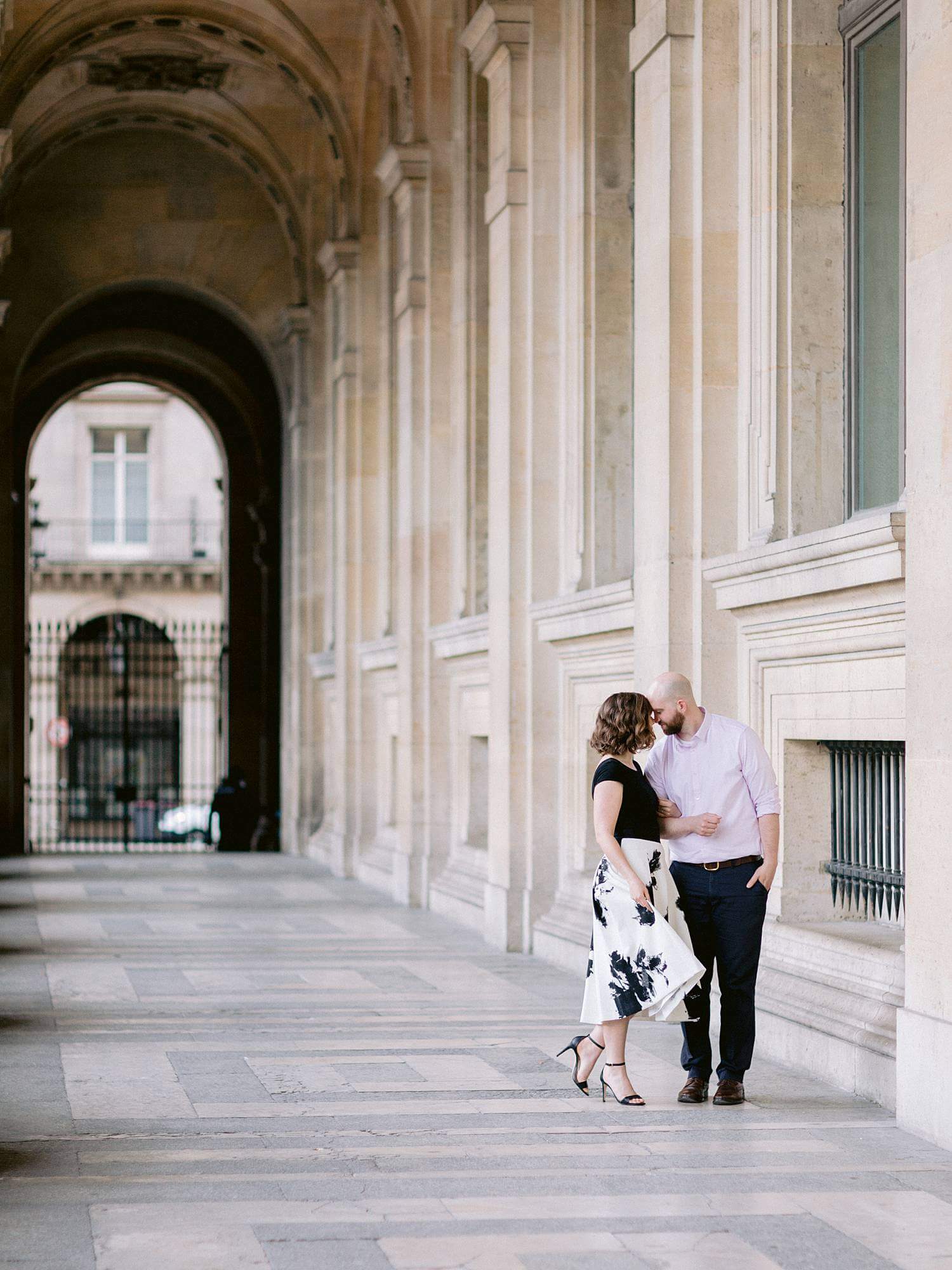 Couple walking through hallway of Louvre Museum