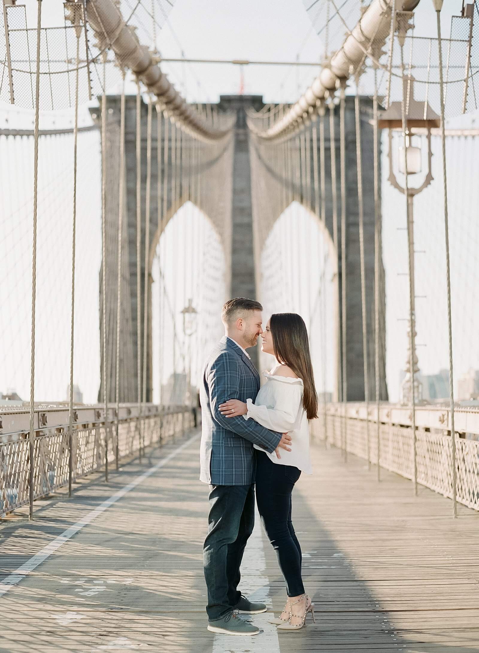 Couple during their engagement session on the Brooklyn Bridge.