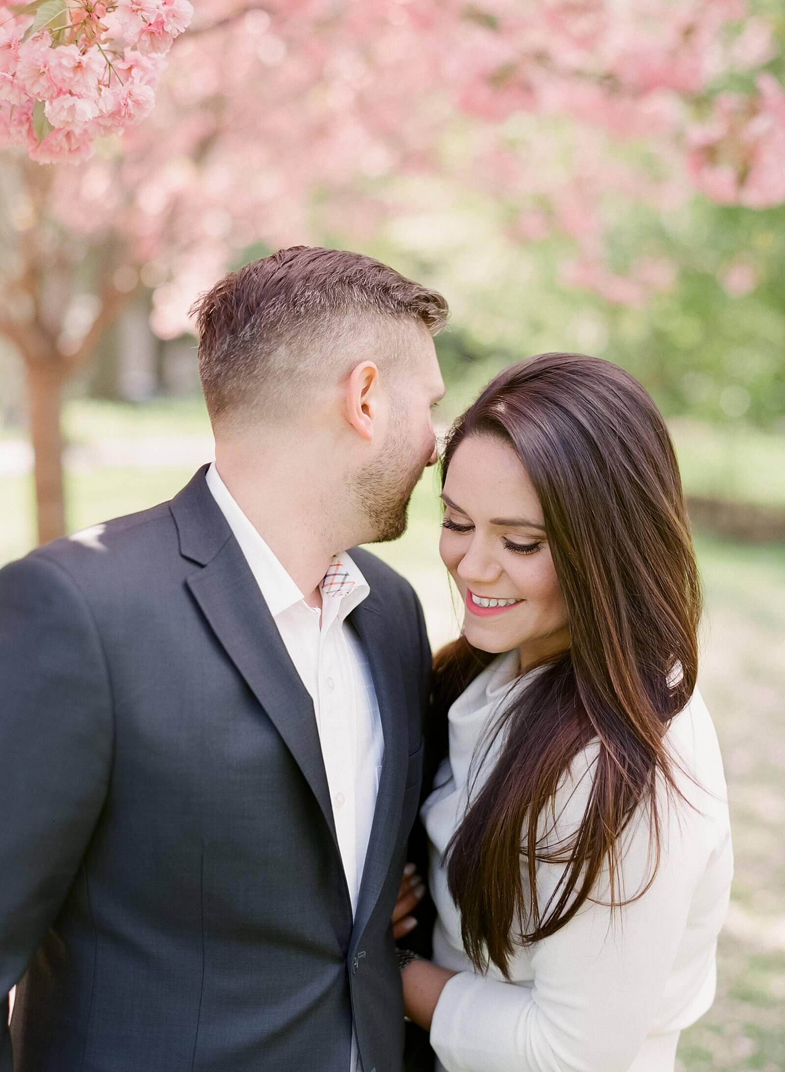 A couple under the cherry blossoms during their engagement session in Central Park in Manhattan.
