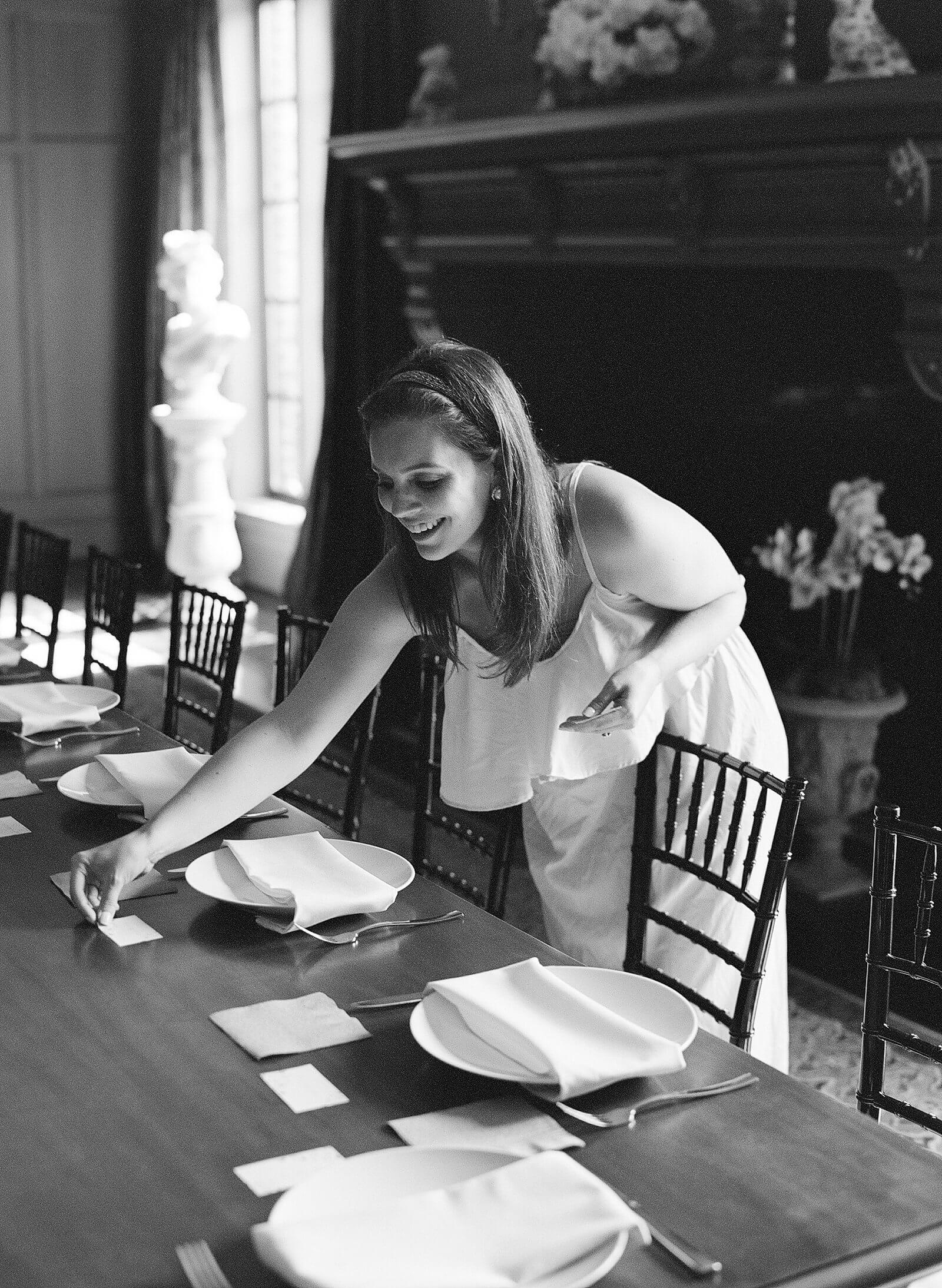 Image of bride setting out place cards for her rehearsal dinner at Dover Hall Estate