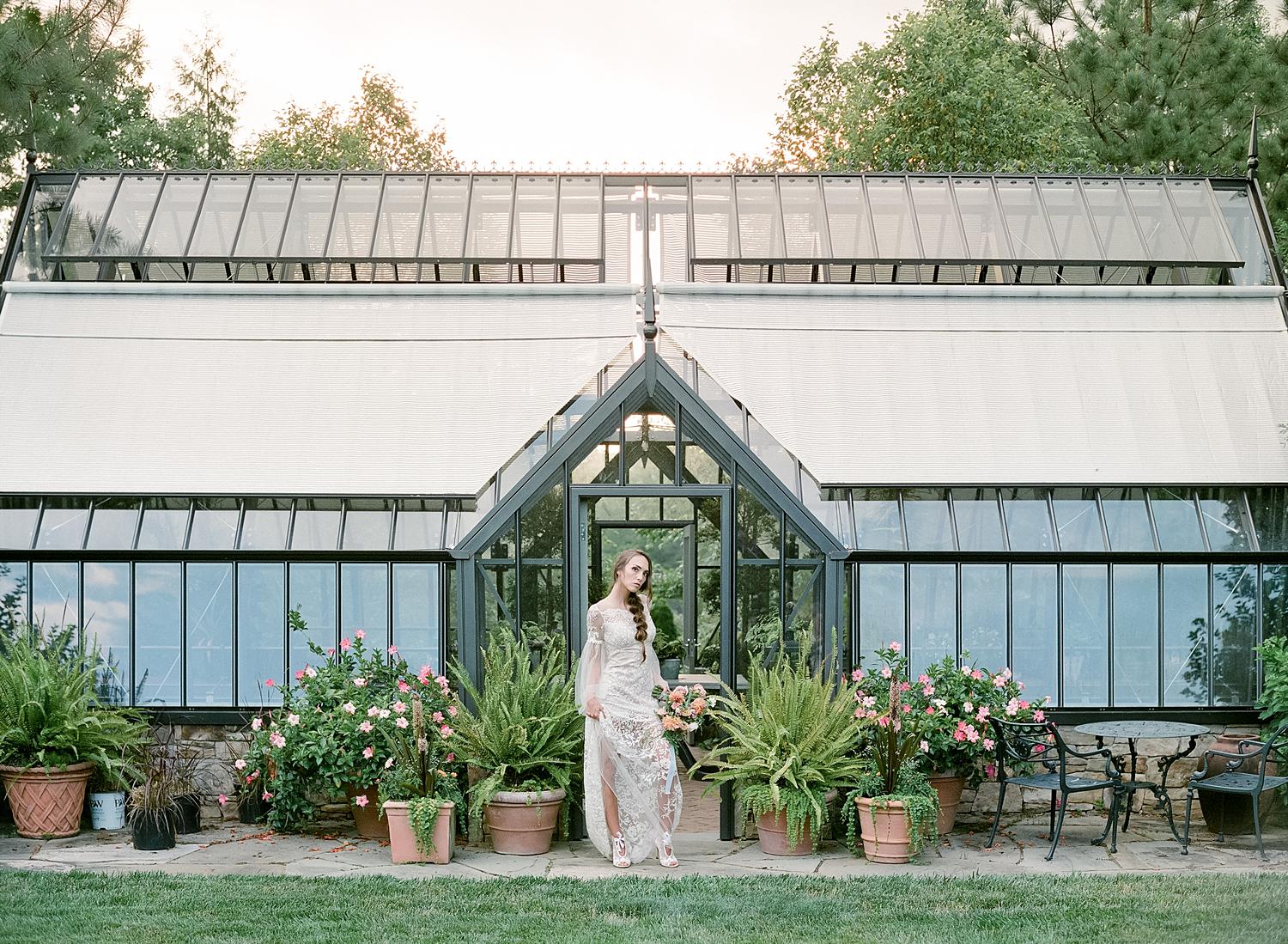Bride in designer Claire Pettibone Gown in front of the greenhouse at Waterperry Farm Wedding