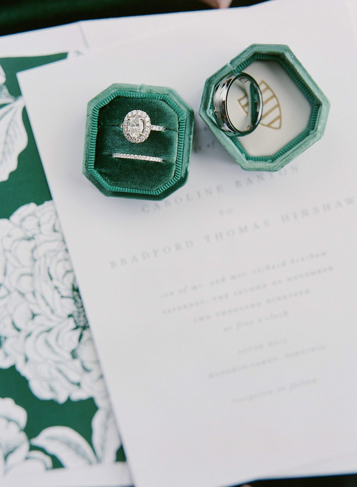 Emerald green ring box on with engagement and wedding bands on invitation suite