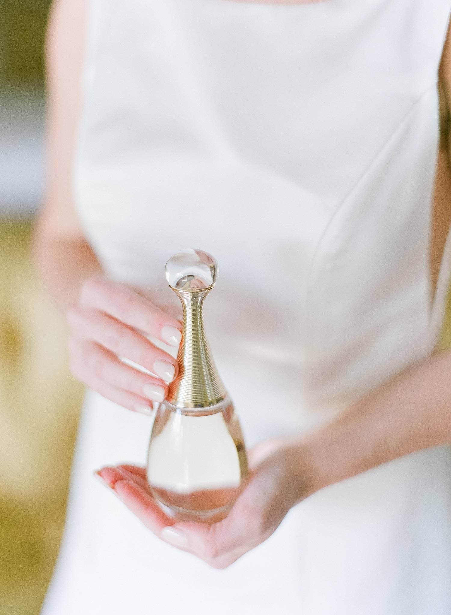 Bride holding her Dior perfume.