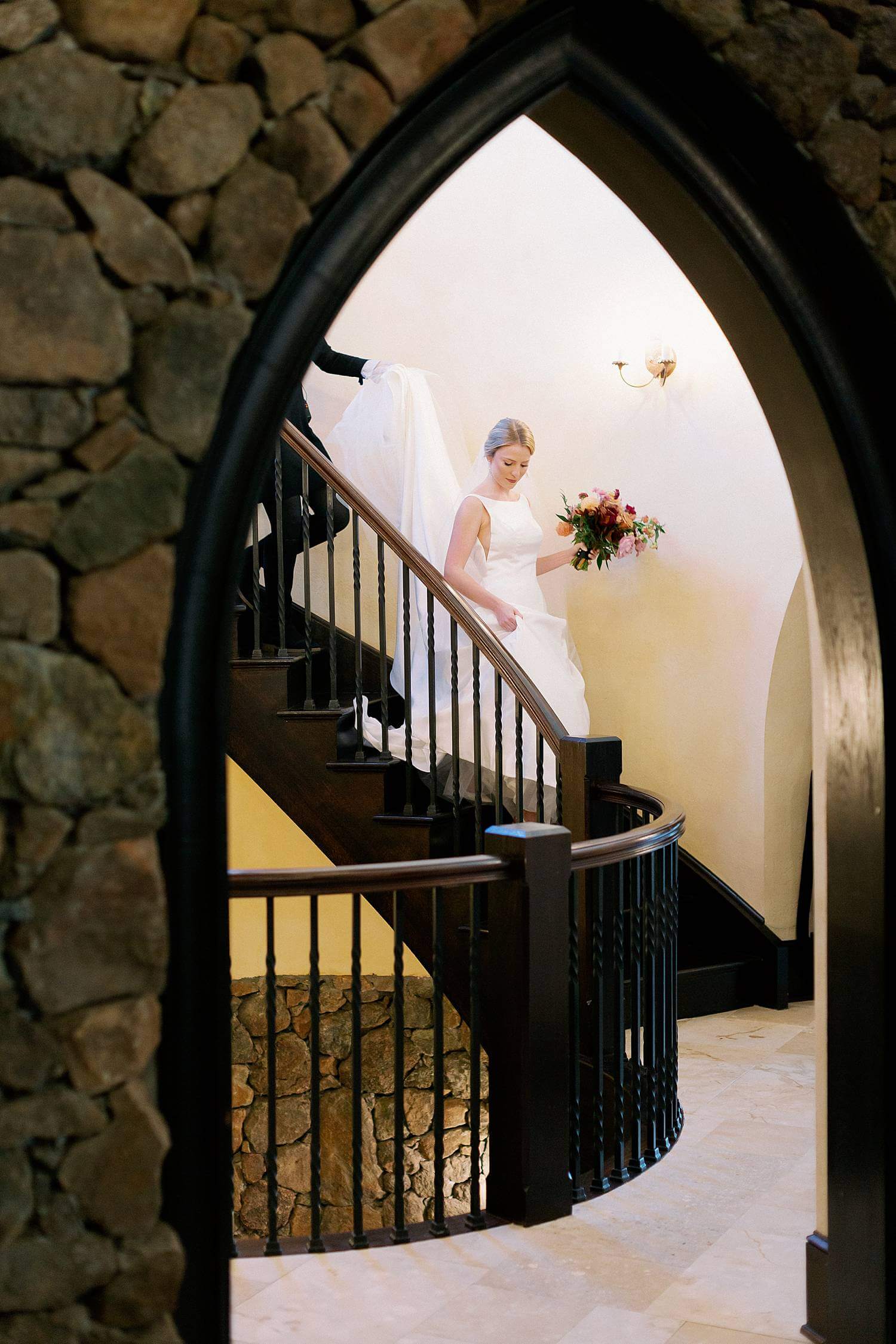 Bride depending spiral staircase on the way to her ceremony at Dover Hall Estate