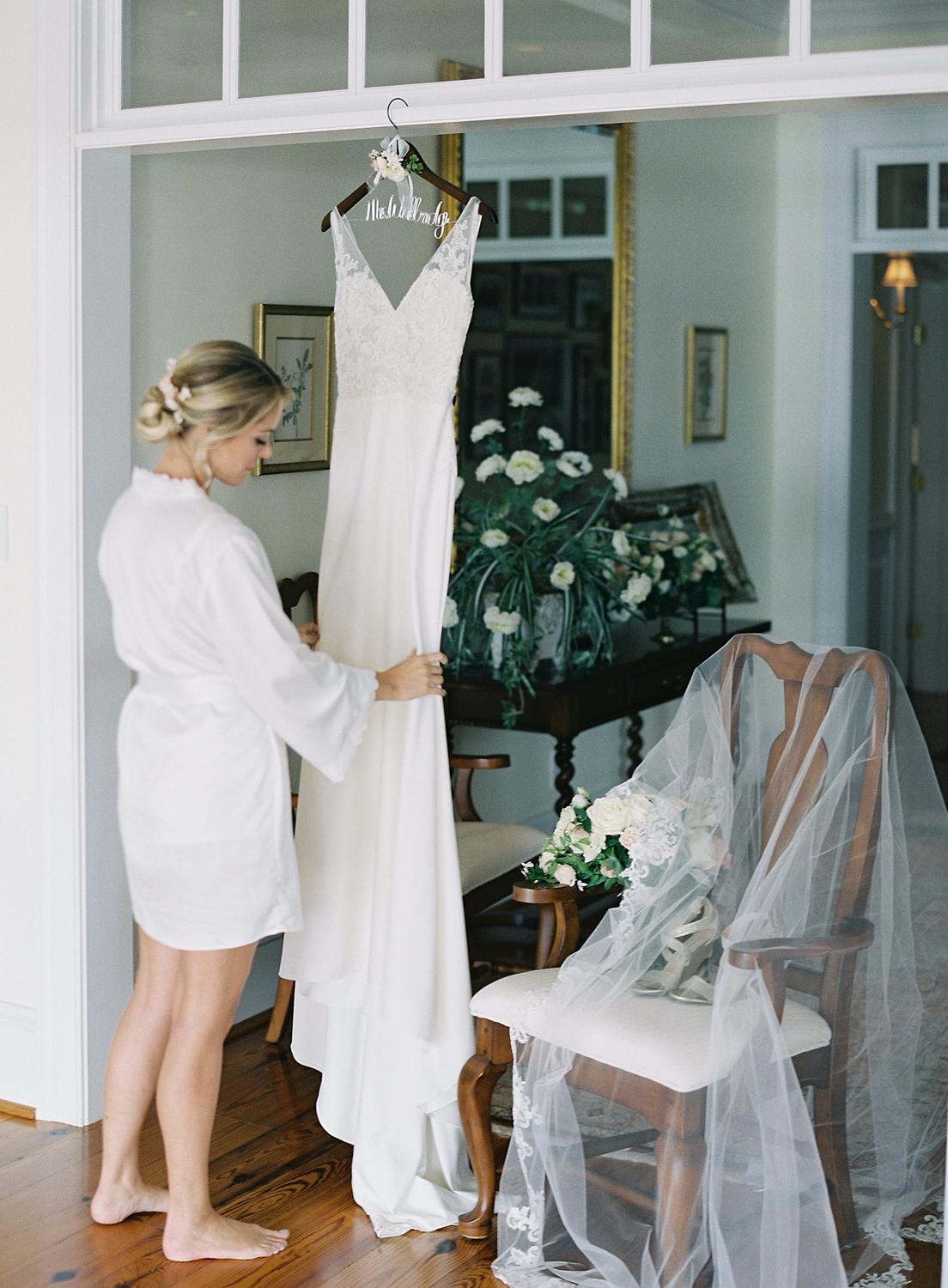 Bride hanging up her wedding gown before her ceremony