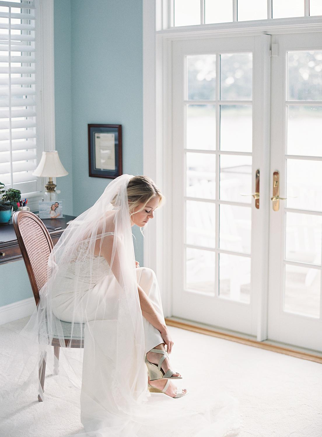 Bride stepping into her wedding shoes for her intimate home wedding.