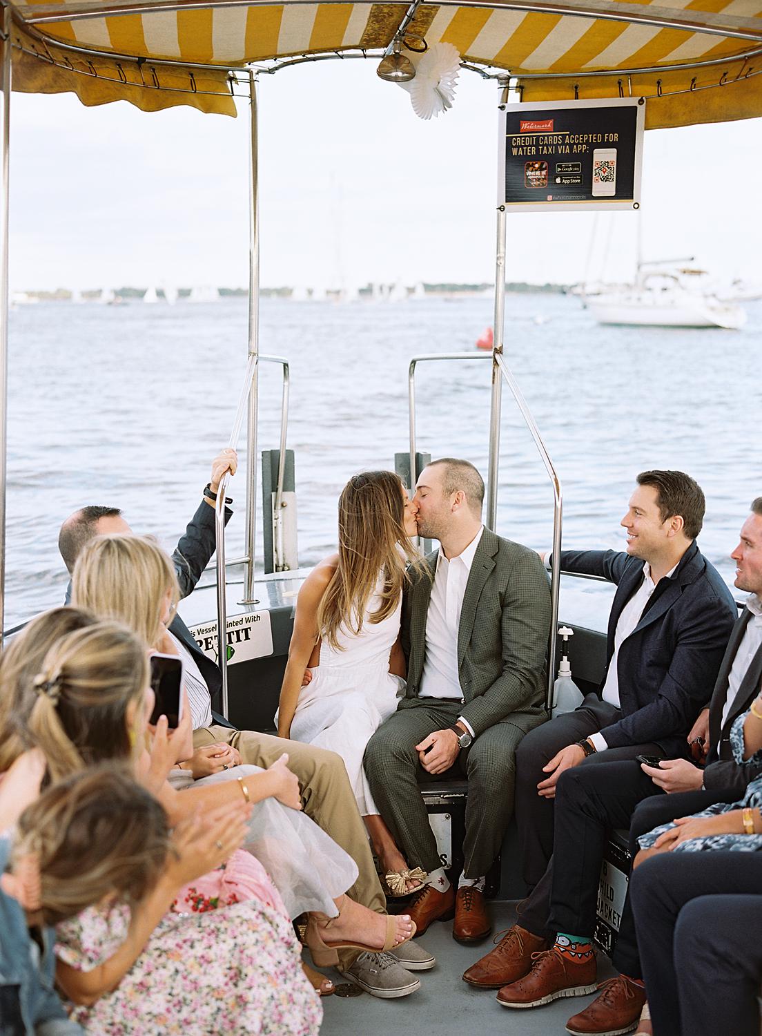 Bride and groom kissing on a water taxi on the way to their rehearsal dinner.