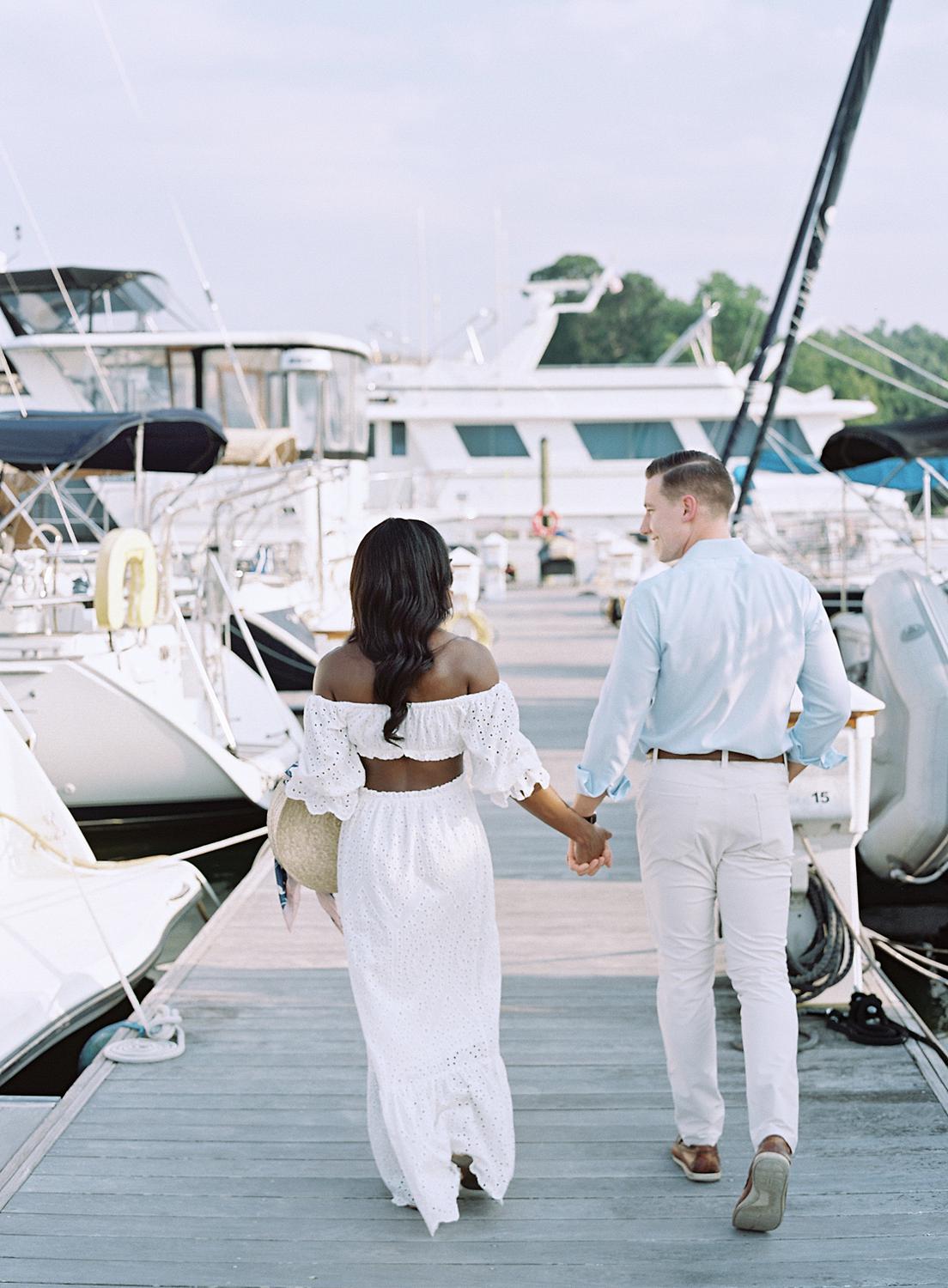 Bride and groom walking along dock at Annapolis engagement session.
