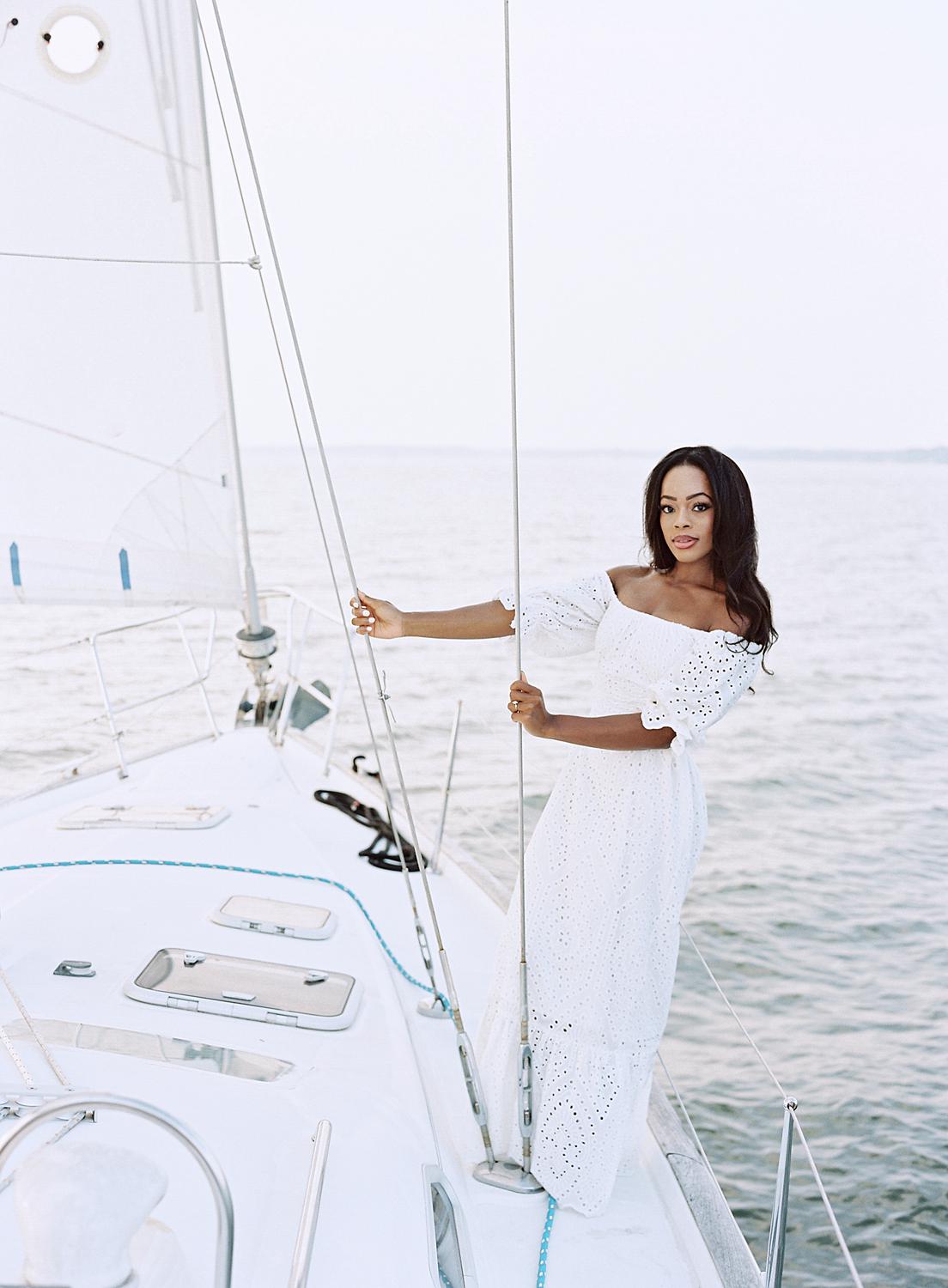 Bride leaning out over the water during Annapolis engagement session.