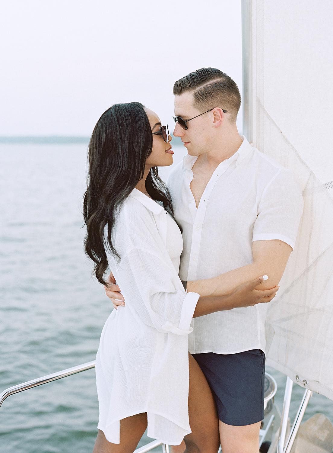 Bride and groom kissing at bow of ship during their engagement session in The Annapolis Harbor.