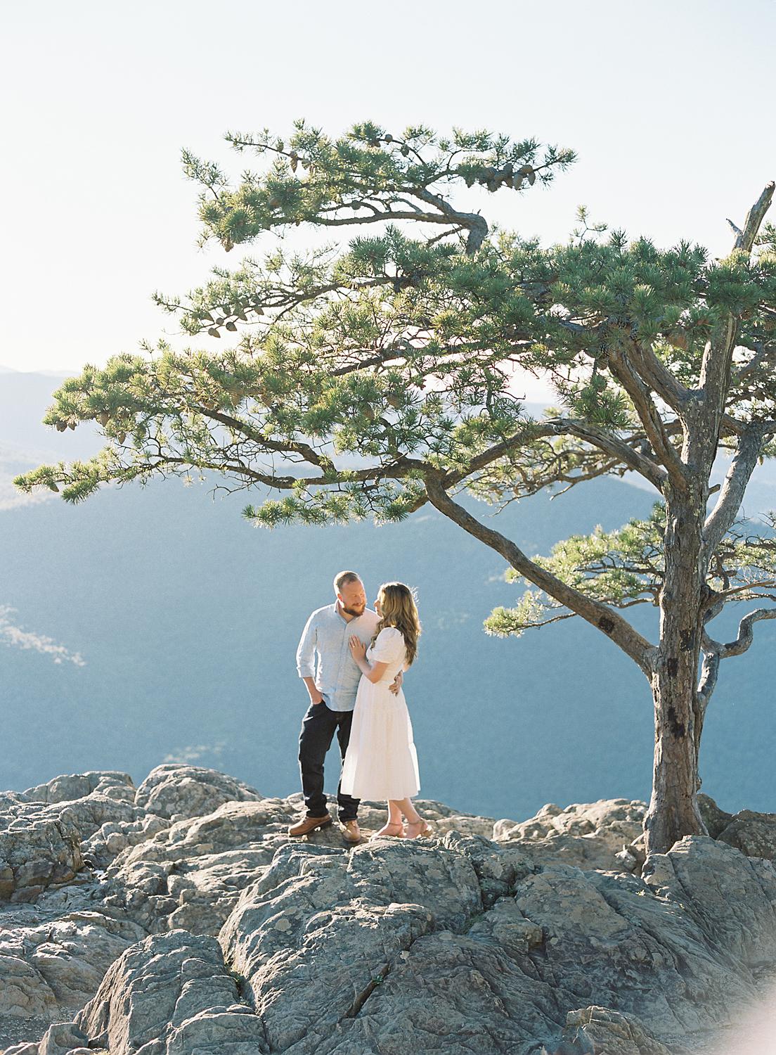 Groom holding bride while atop Ravens Roost During their Blue Ridge Mountains engagement session.