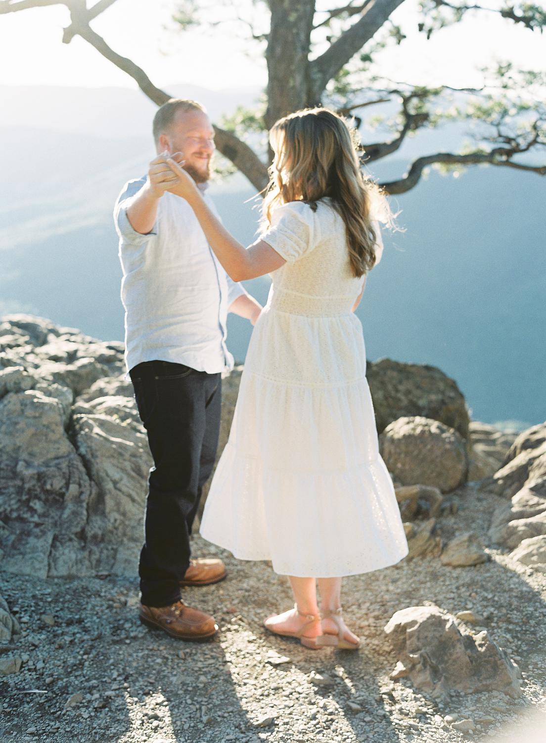 Bride and groom dancing together atop Ravens Roost for their Blue Ridge Mountains engagement session.