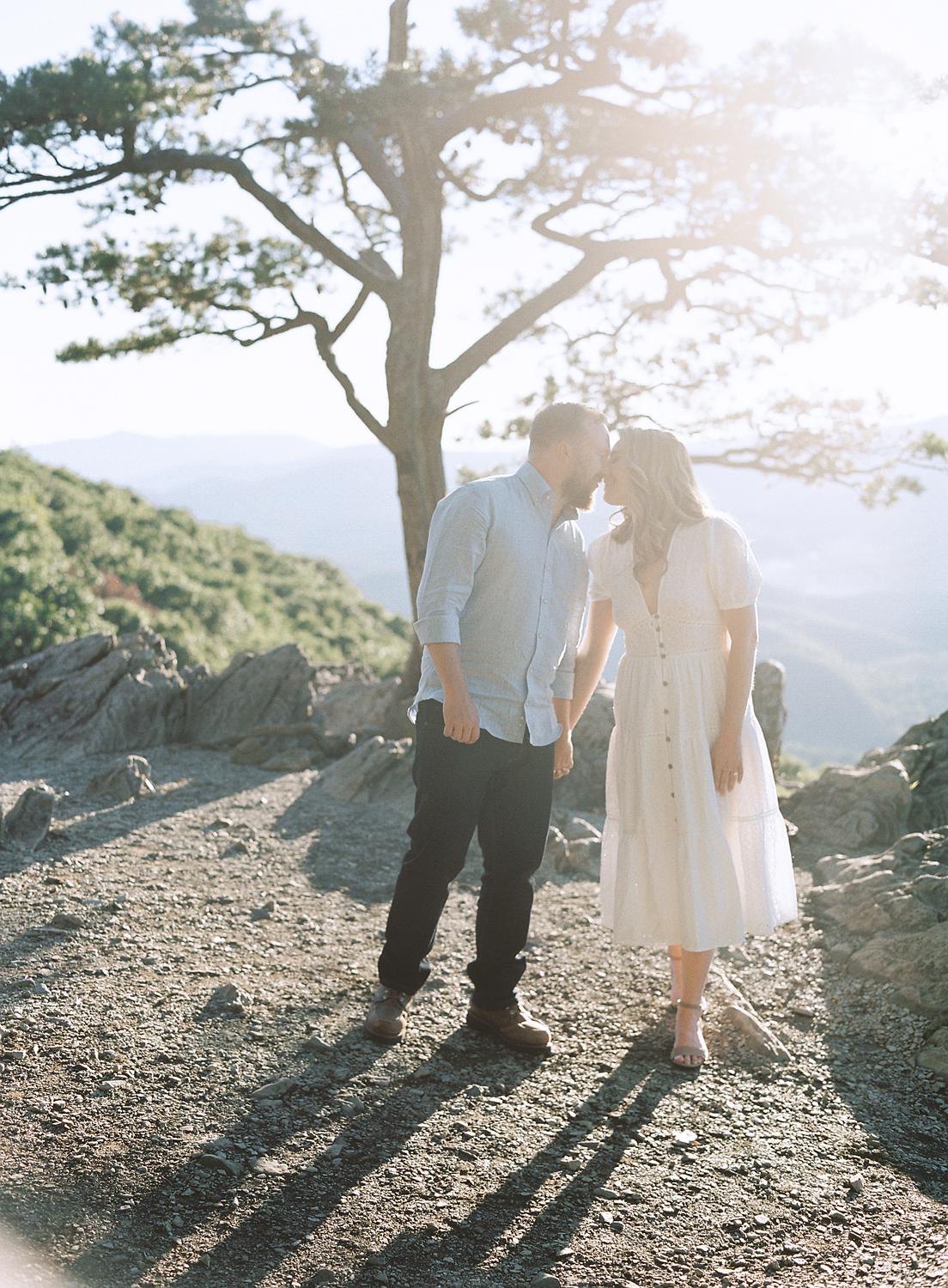 Bride and groom walk together atop Ravens Roost during their engagement session in The Blue Ridge Mountains.