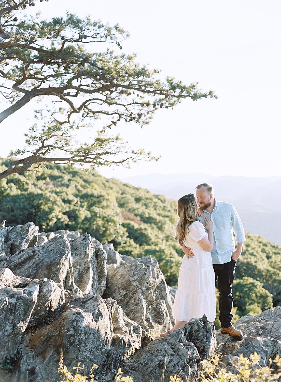 Bride and groom embracing at their Blue Ridge Mountains engagement session atop Ravens Roost.