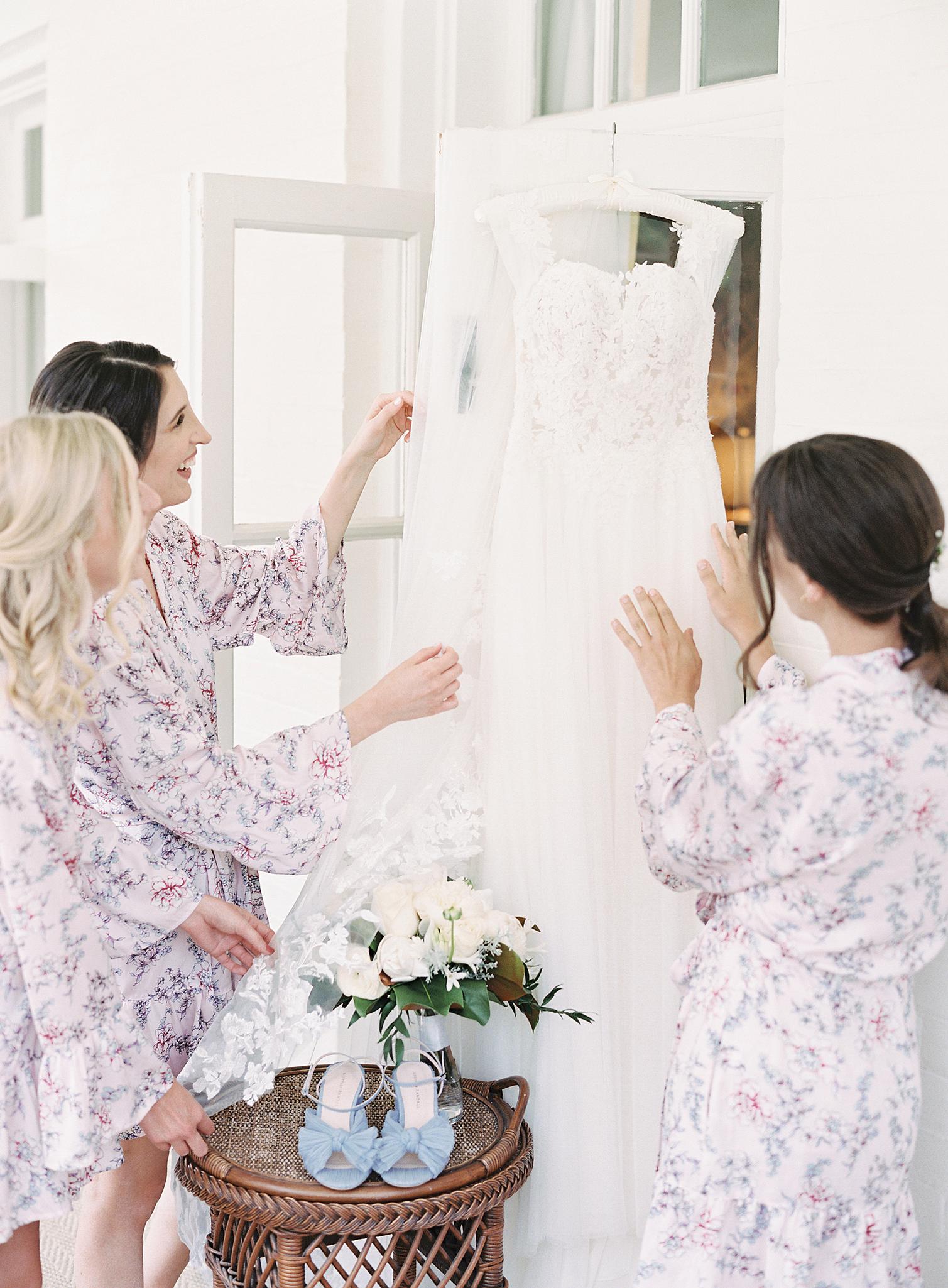 Bridesmaids adjusting the wedding gown for a wedding at The Omni Homestead Resort.