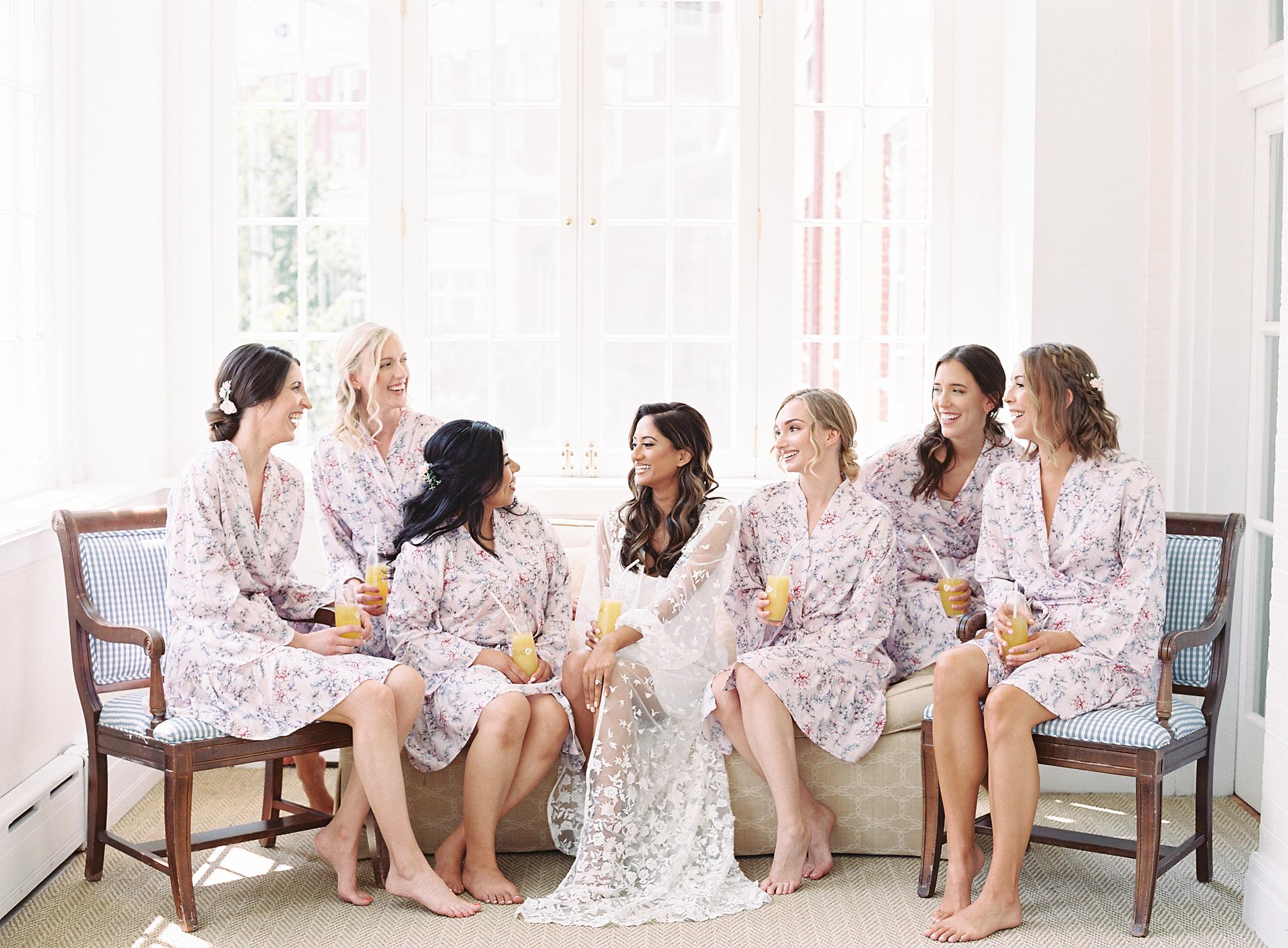 Bride and bridesmaids in robes laughing together before the Omni Homestead Resort wedding.