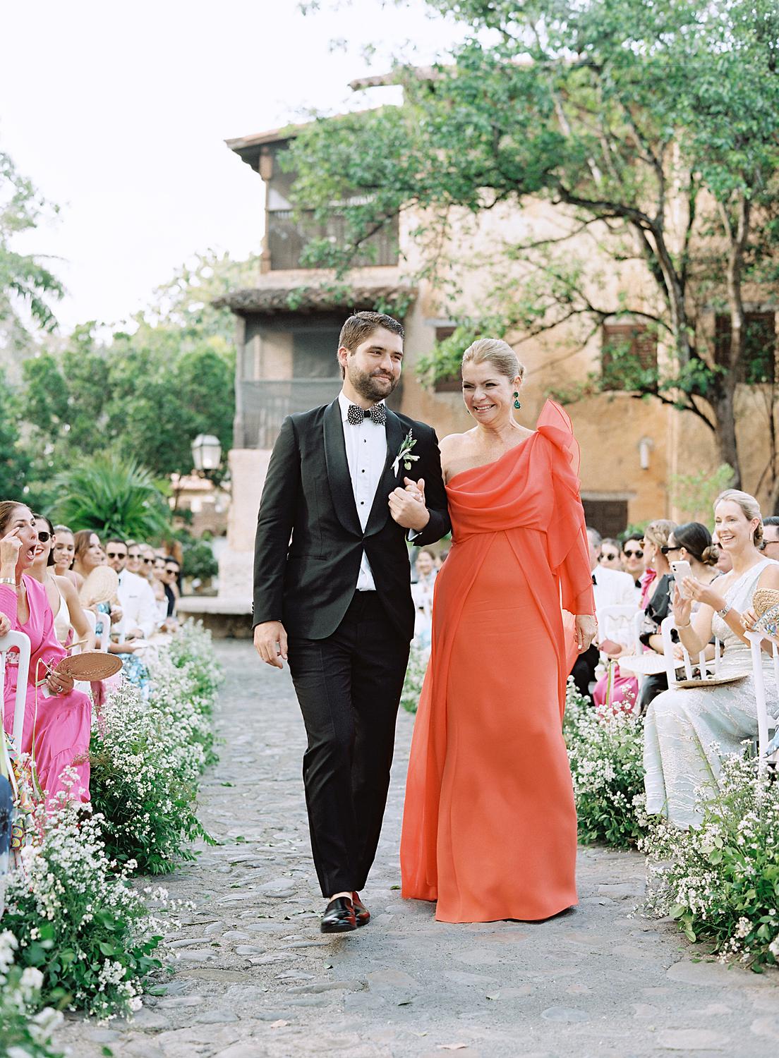 Groom walks in with his mother for a wedding at Altos de Chavón wedding.