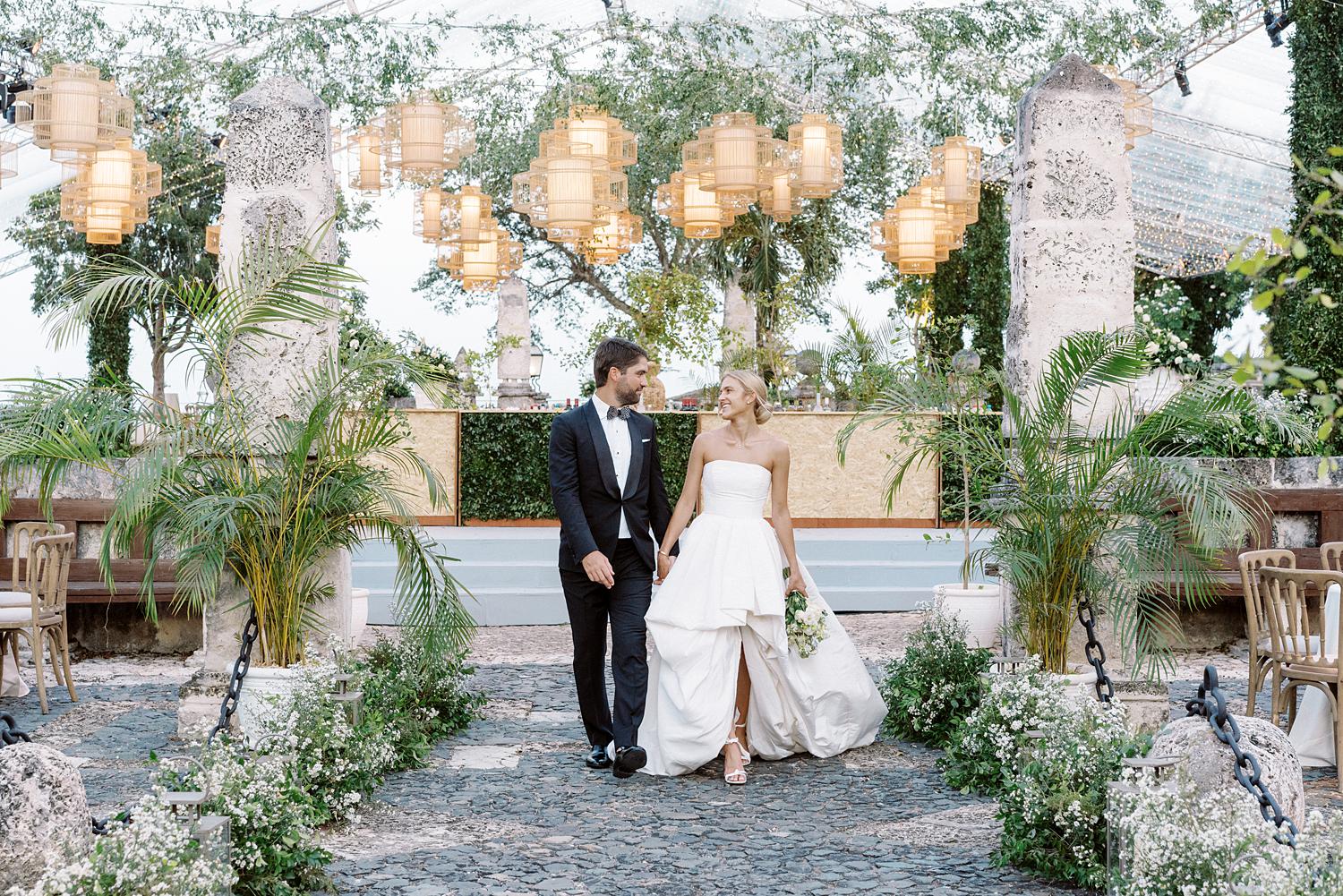 Bride and groom walk inside of their beautiful reception at Altos de Chavón.