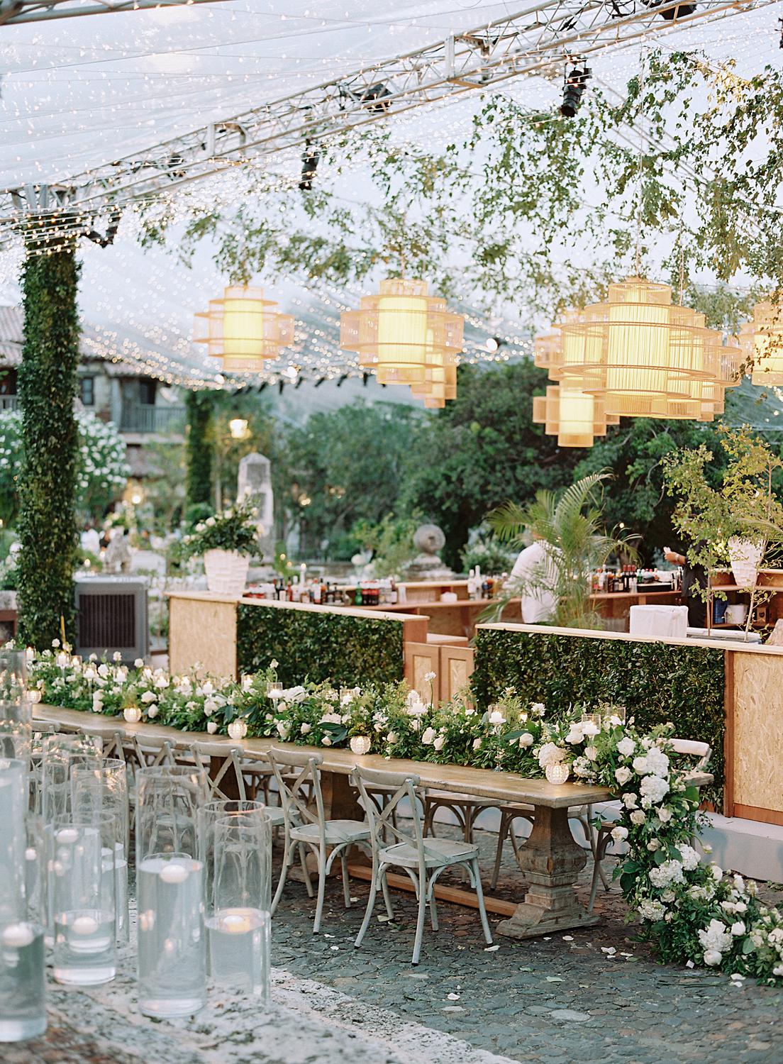 Long table with cascading florals and hanging lanterns at reception during an Altos de Chavon wedding.