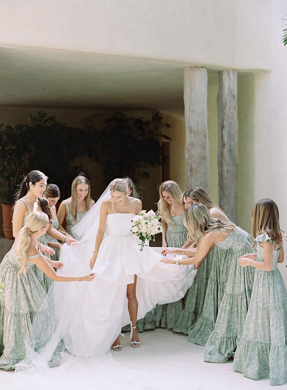 Bridesmaids all loving on and commenting about the brides dress just before their Altos de Chavón wedding.