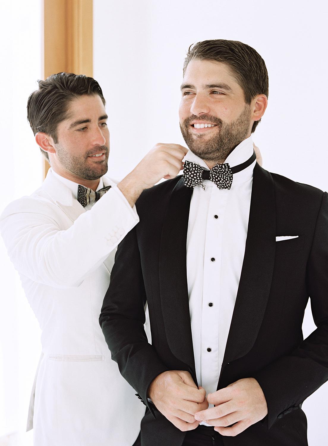 Groom's brother helping straighten his bowtie before heading out to their Altos de Chavón wedding.