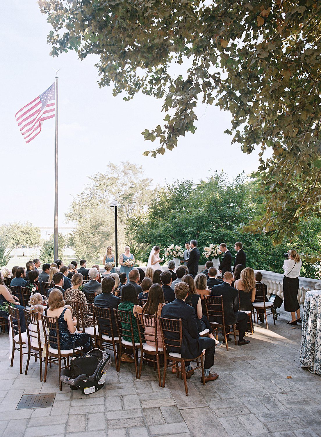 Guests watching bride and groom's ceremony on the patio at a DAR Constitution Hall wedding.