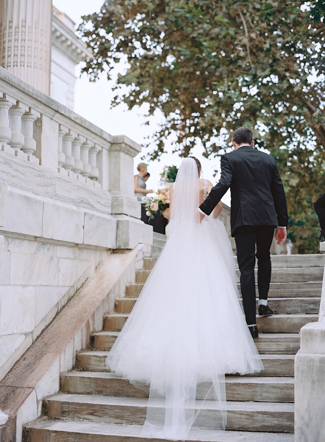 Bride and groom walking up the steps to the patio at their DAR Constitution Hall wedding.