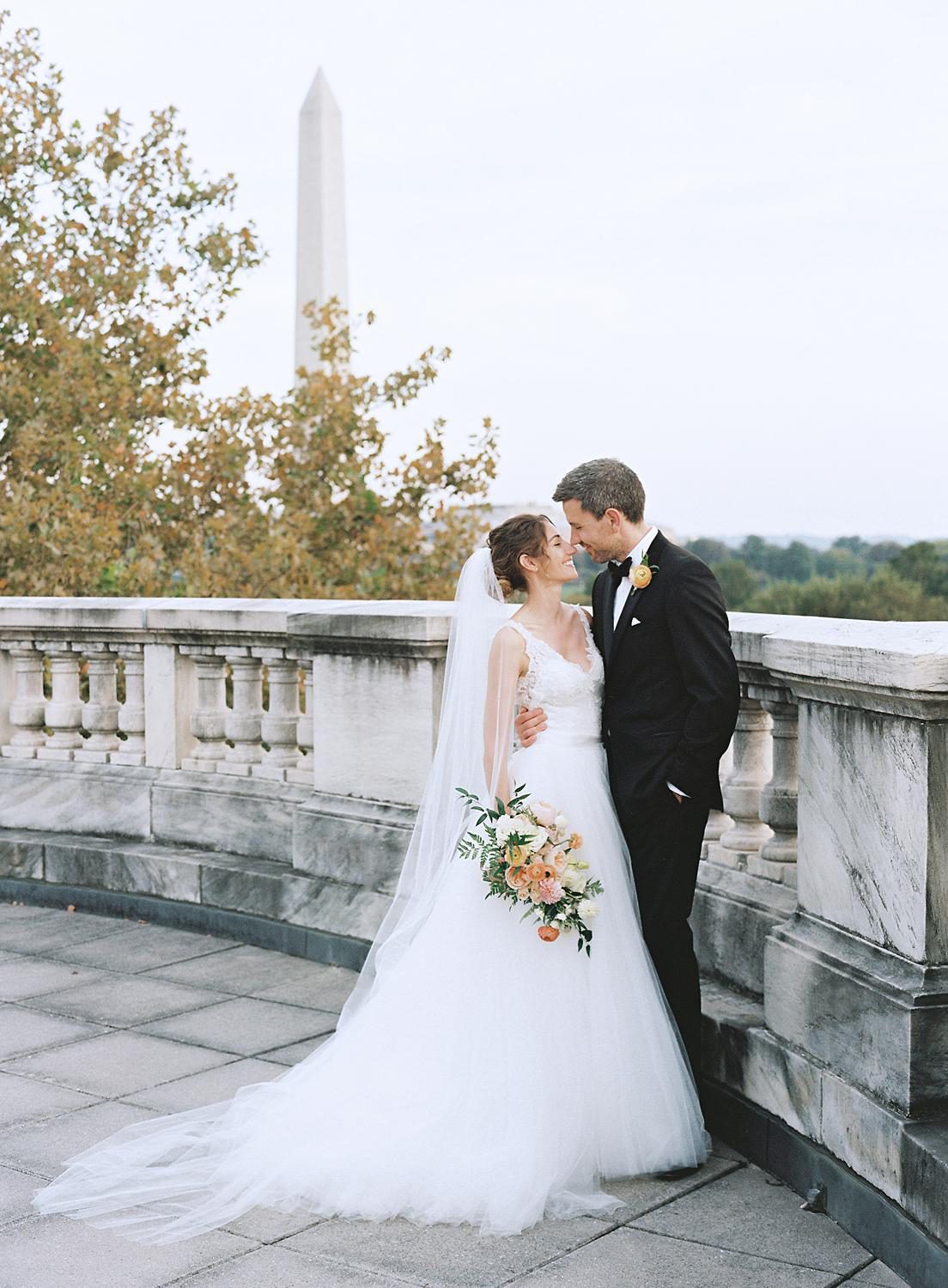 Bride and groom embracing on the rooftop at their DAR Constitution Hall wedding.