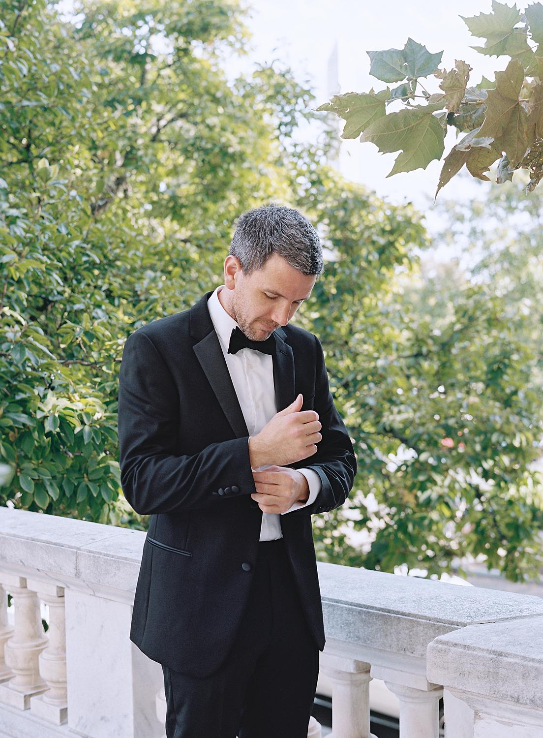 Groom adjusting his cuffs while getting ready for his wedding at DAR Constitution Hall wedding.