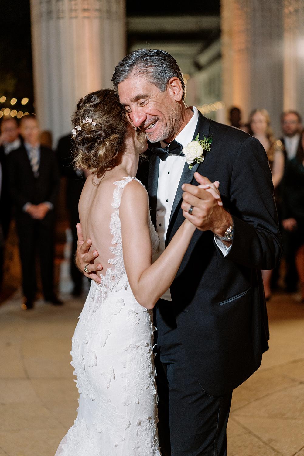 Father and daughter sharing a dance under the columns of the DAR Constitution hall during the reception.