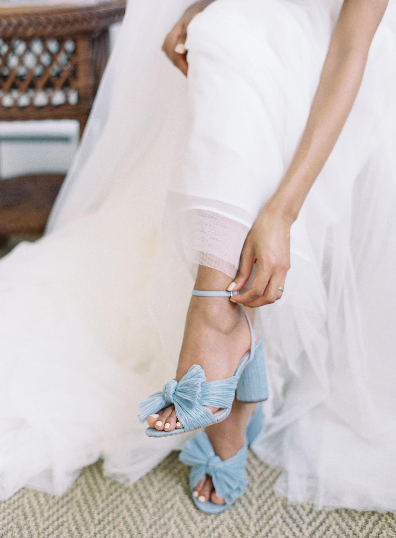 Bride putting on her blue Loeffler Randall shoes before her Omni Homestead Resort wedding.