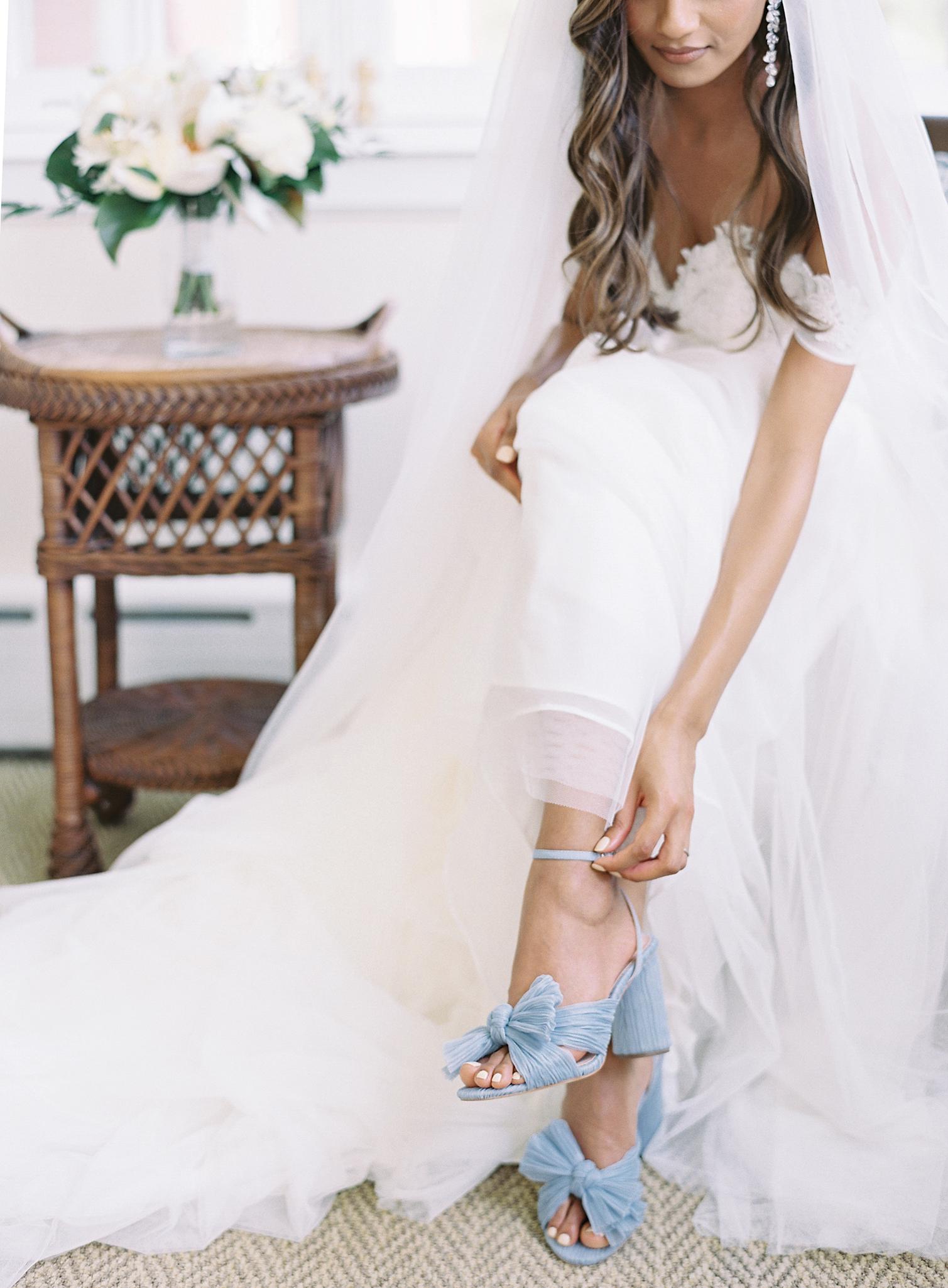 Bride putting on her blue Loeffler Randall shoes before her Omni Homestead Resort wedding.