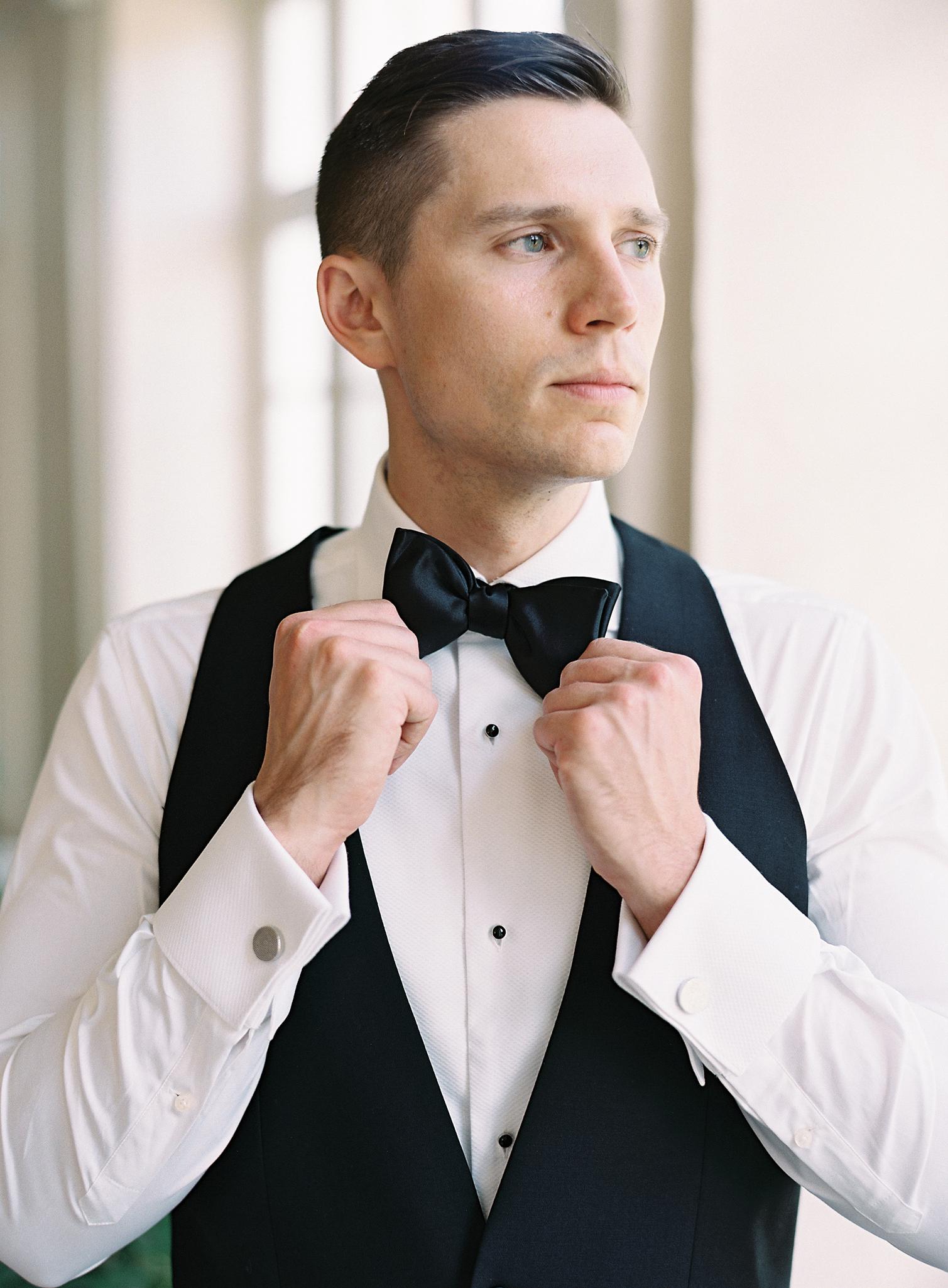 Groom putting on his bow tie before his Omni Homestead Resort wedding.