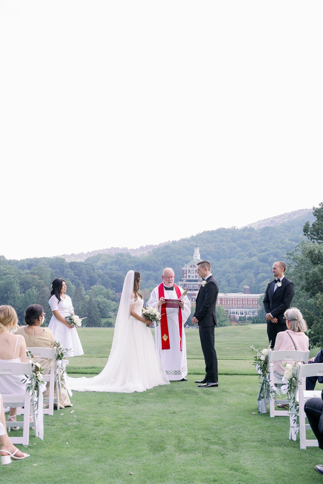 Bride and groom saying their vows overlooking The Omni Homestead Resort.