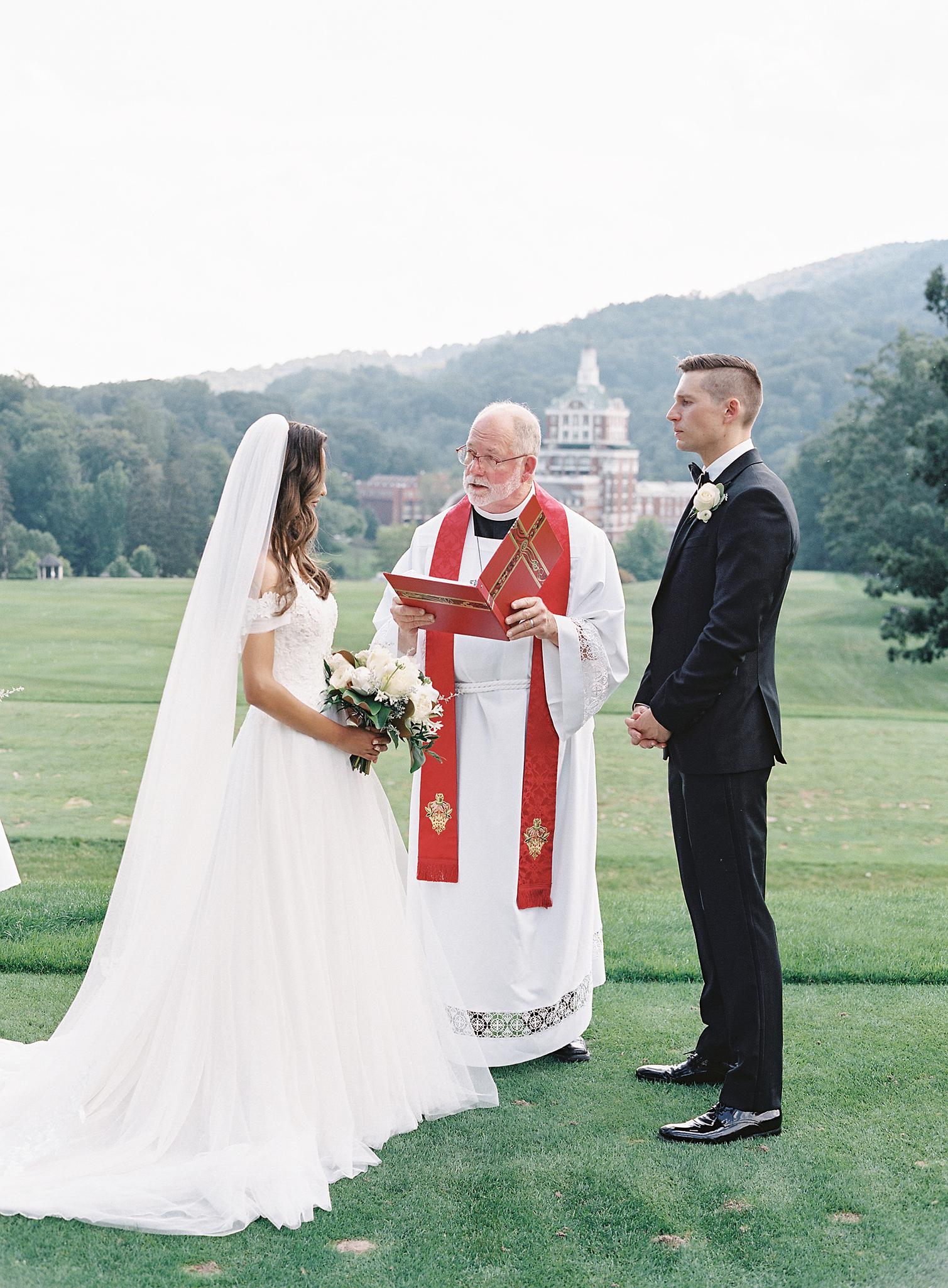 Couple getting married on the golf course overlooking The Omni Homestead Resort.