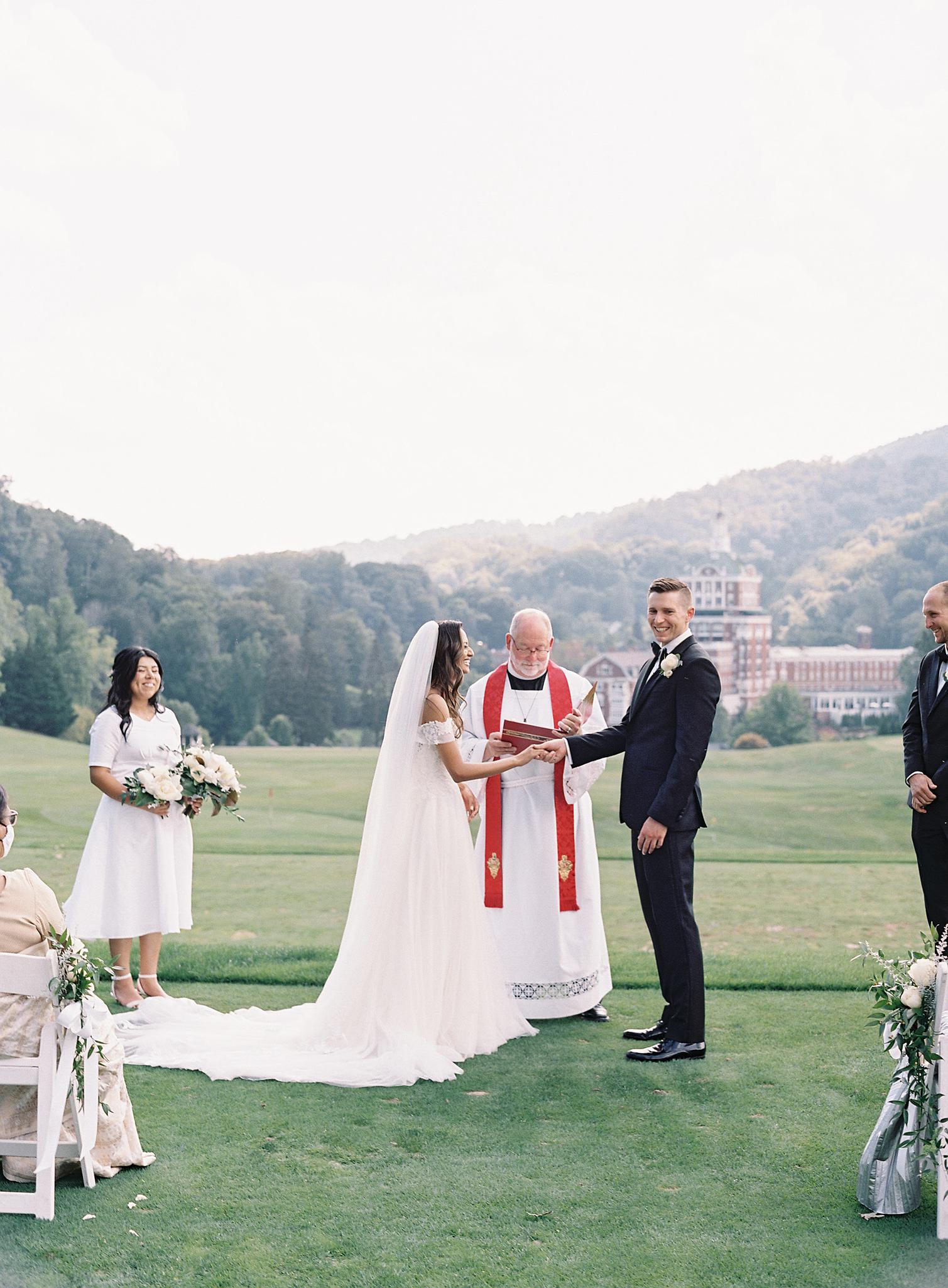 Couple getting married on the golf course overlooking The Omni Homestead Resort.