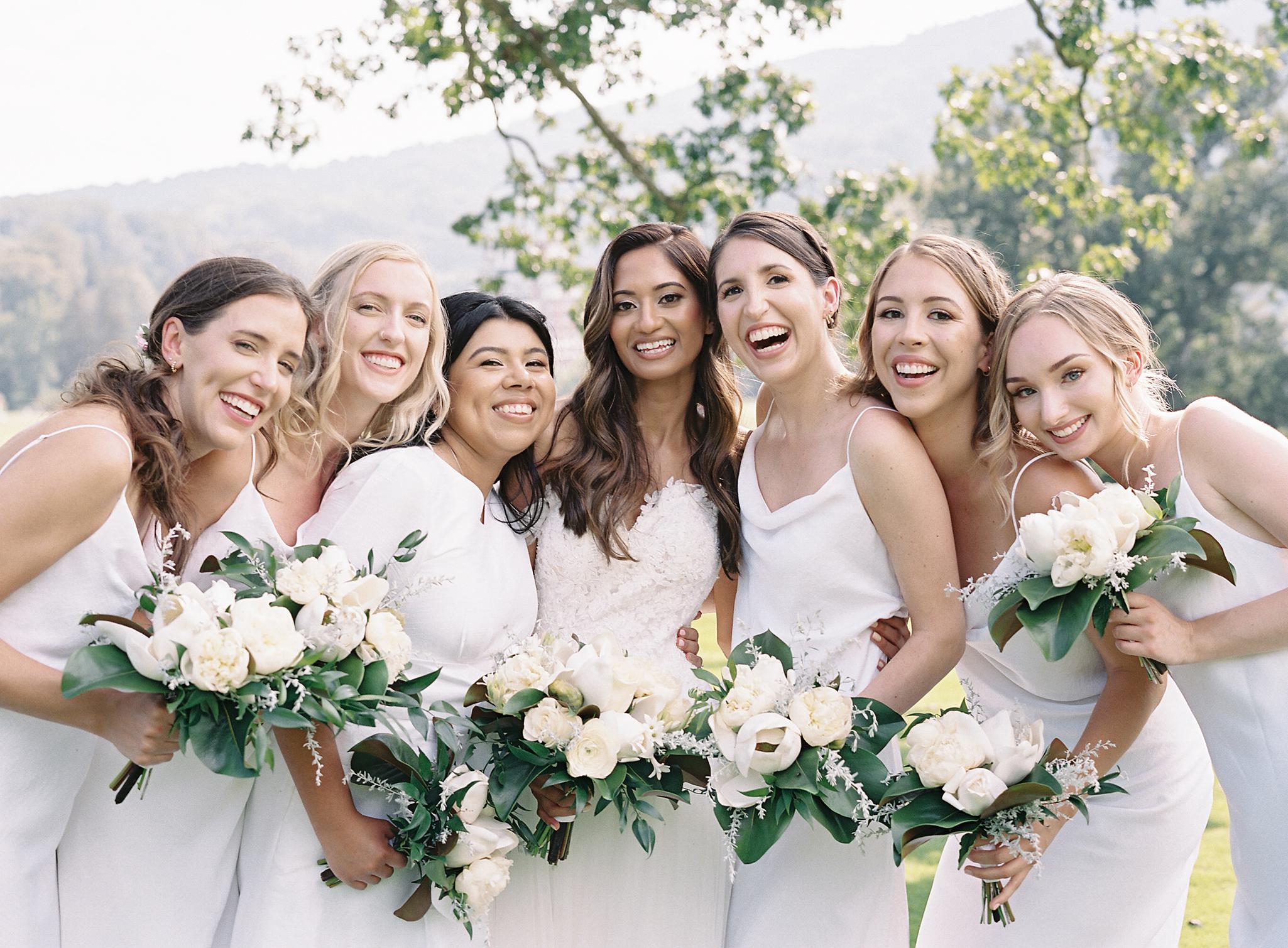 Bride and bridesmaids embracing after a wedding at The Omni Homestead Resort.