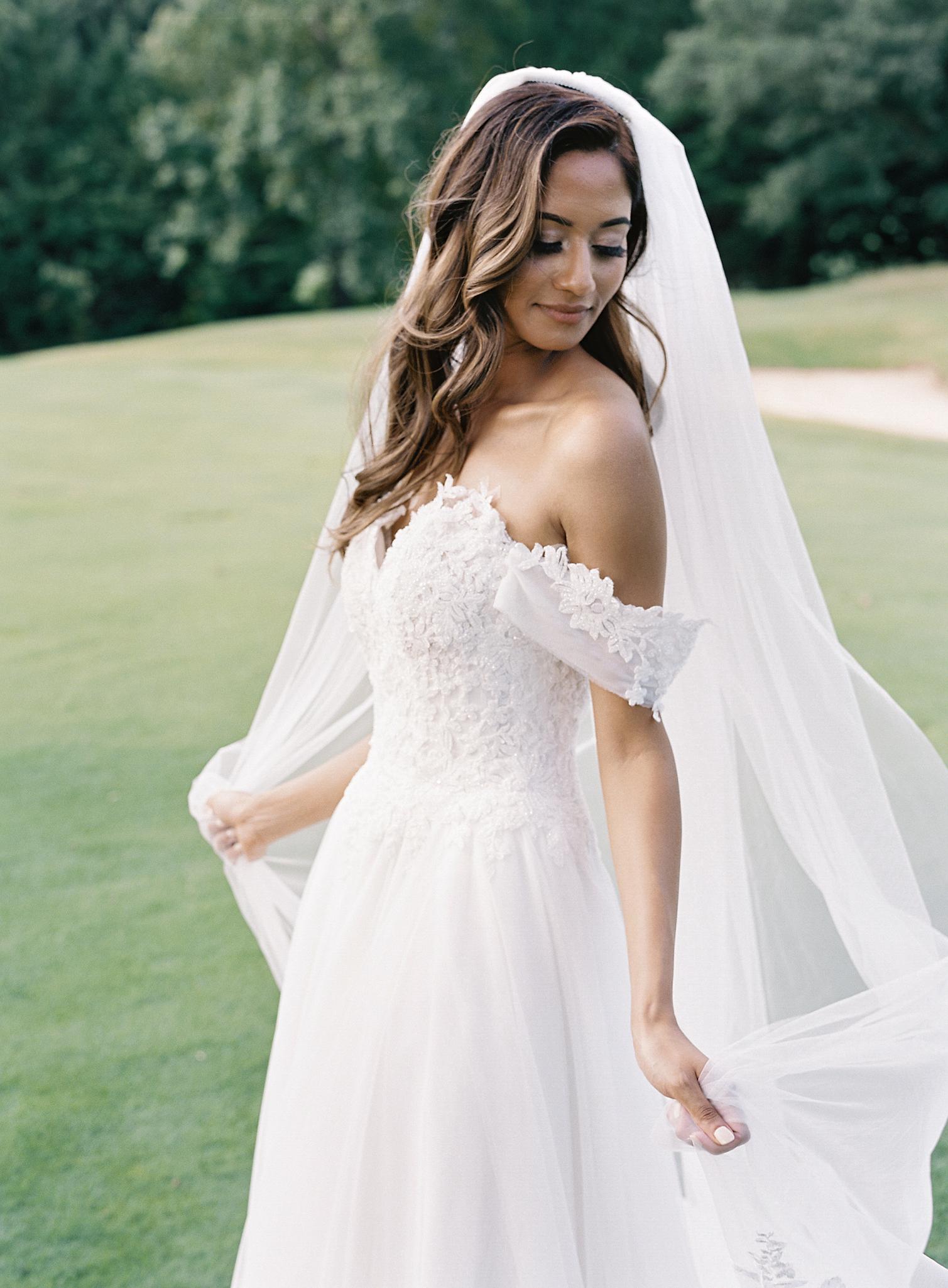 Bride catching her veil as the wind blows through it after her wedding at The Omni Homestead Resort.