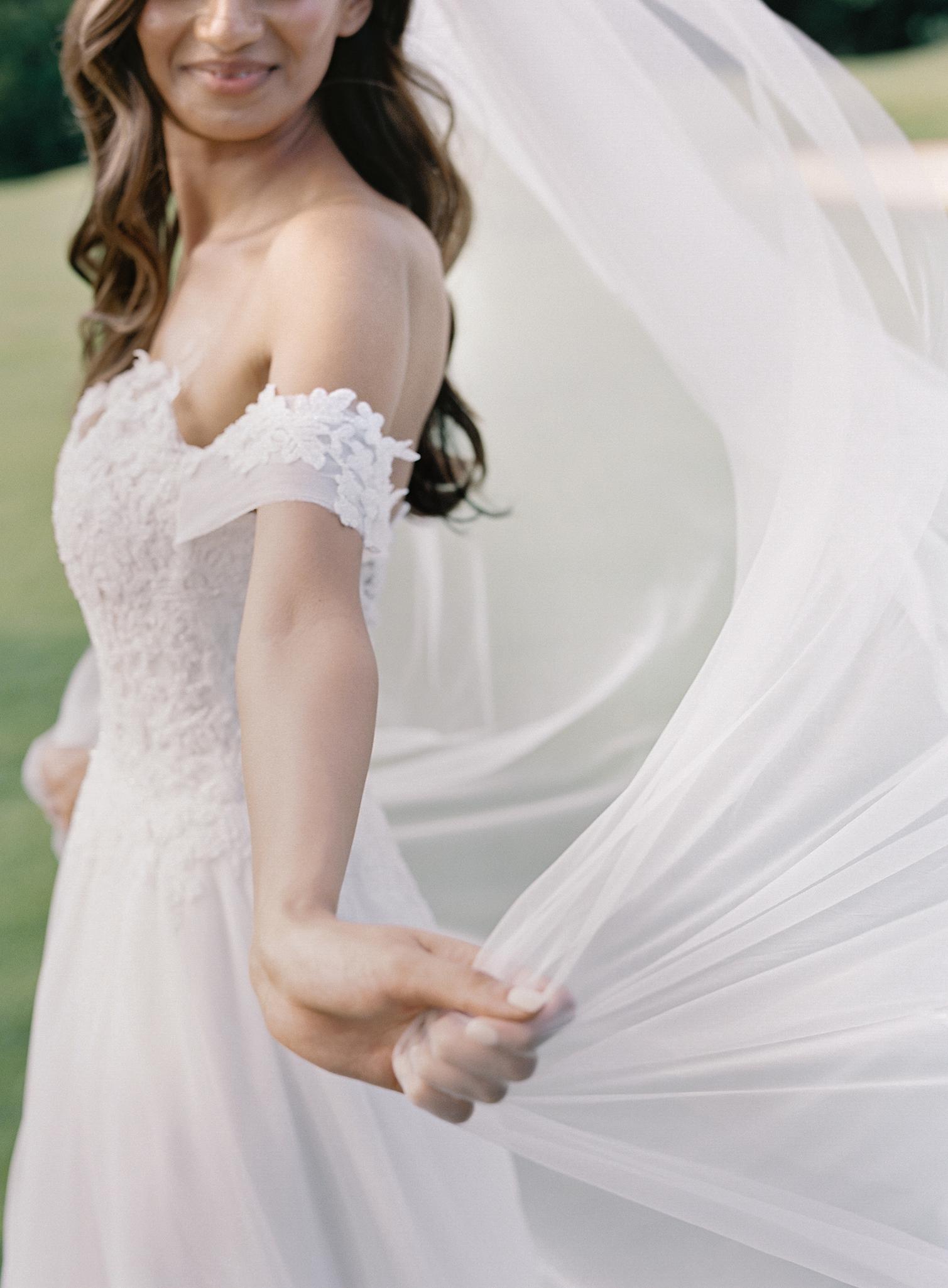 Bride catching her veil as the wind blows through it after her wedding at The Omni Homestead Resort.