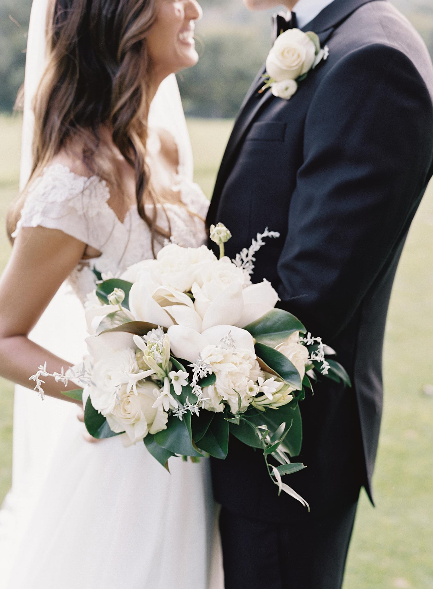 Bride and groom kissing as they hold their bouquet during the wedding at The Omni Homestead Resort.