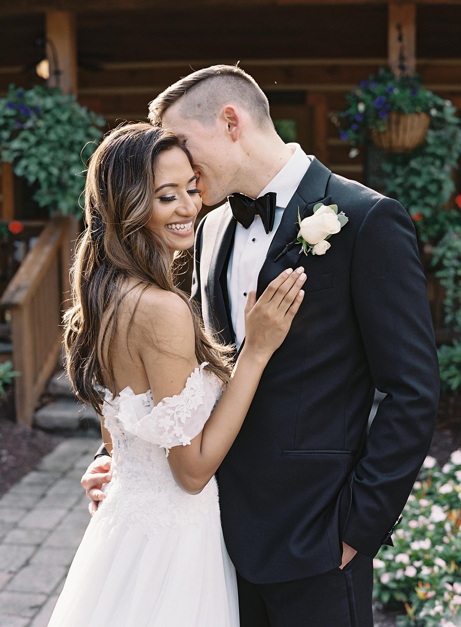 Groom whispering into the bride's ear just outside of their reception at The Omni Homestead Resort.