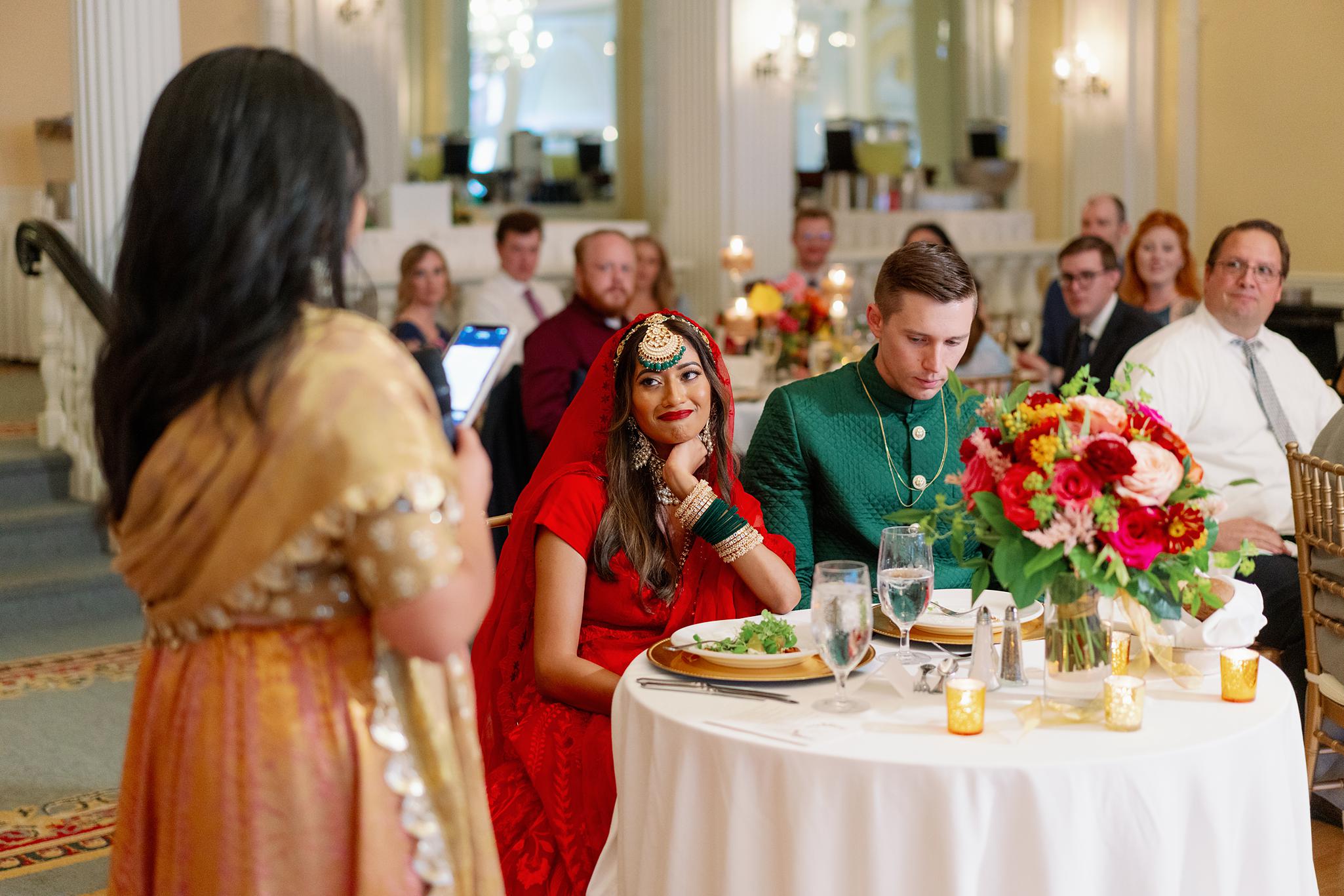 Bride watching as the maid of honor gives her speech to the bride and groom at an Omni Homestead Resort wedding.