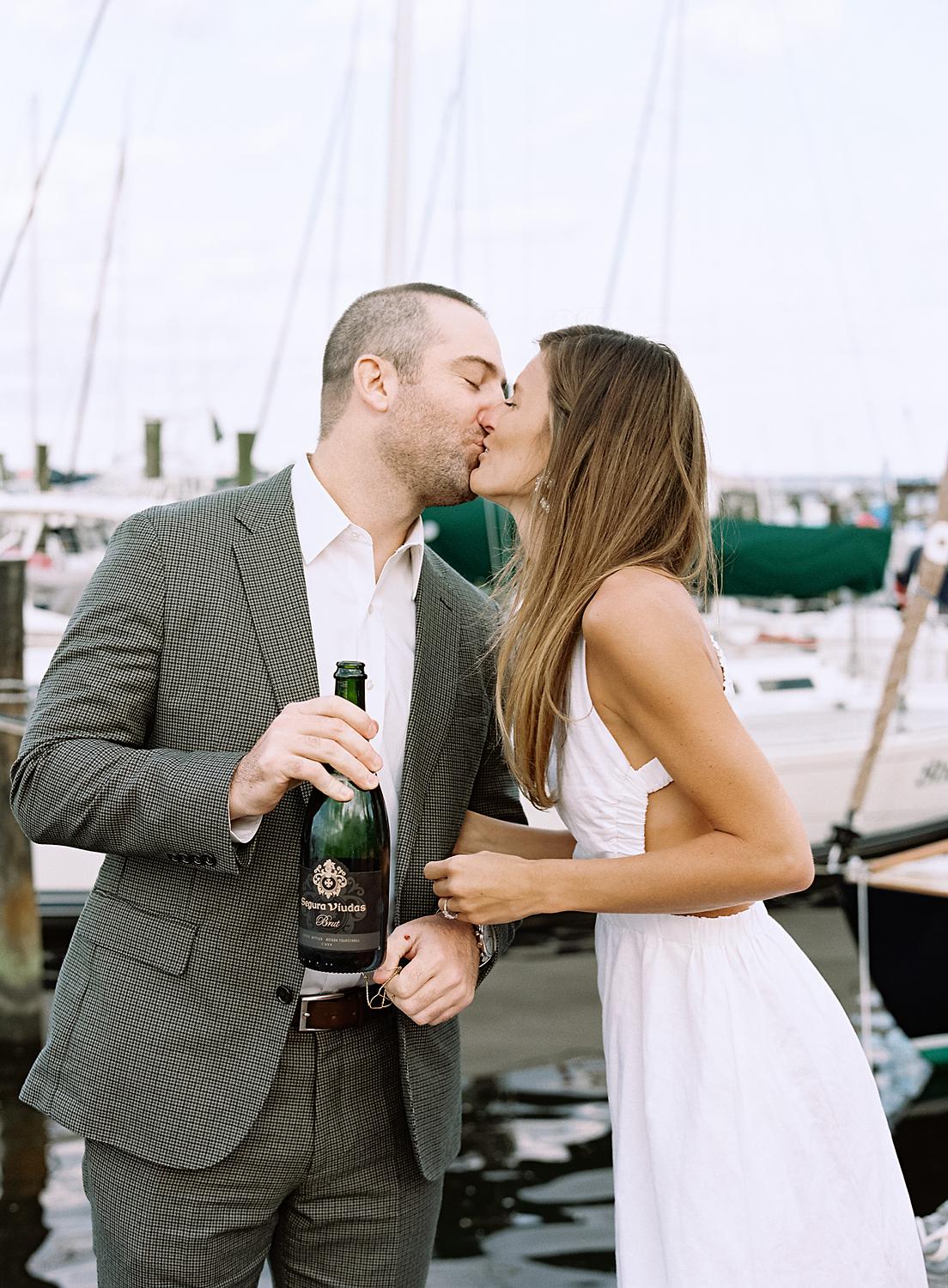 Bride and groom opening up champagne during their rehearsal dinner on The Annapolis Harbor.