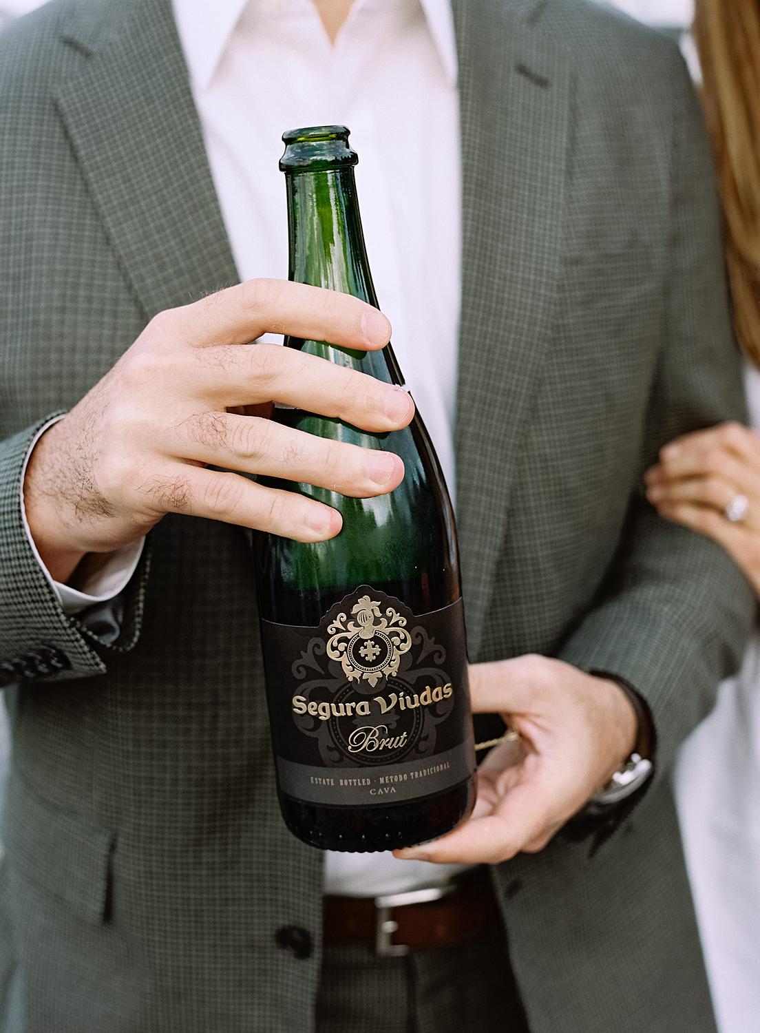 Bride and groom opening up champagne during their rehearsal dinner on The Annapolis Harbor.