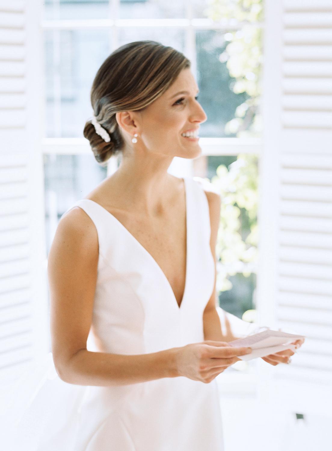 Bride reading letter from groom just before her William Paca House Wedding in Annapolis