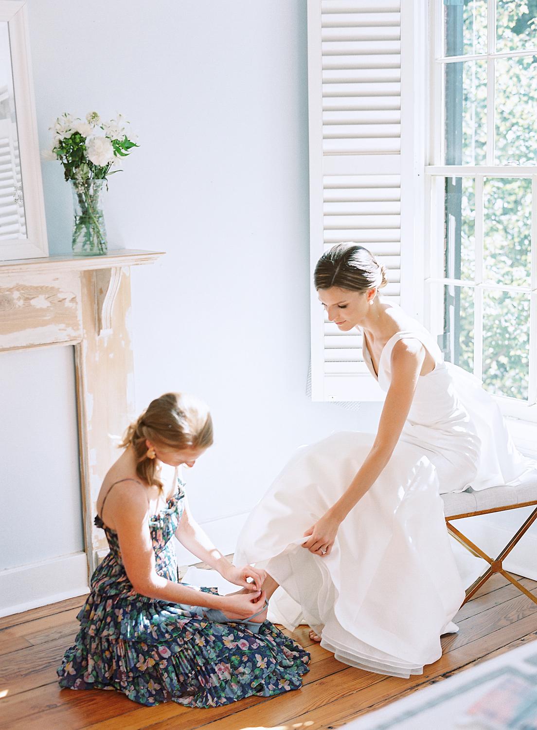 Bride stepping into her shoes before her William Paca House Wedding in Annapolis