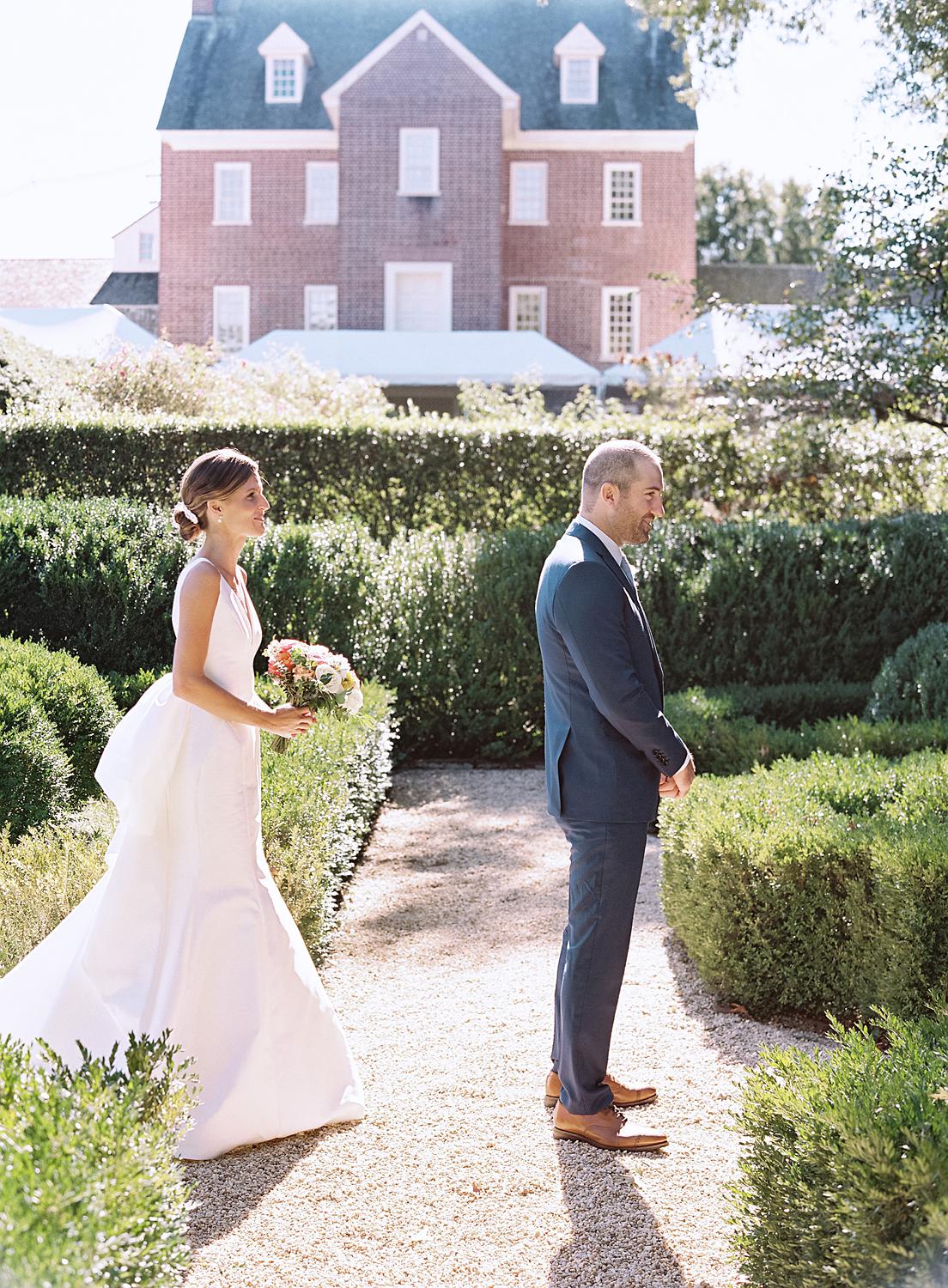 Bride walking up to her groom during their first look at their William Paca House wedding in Annapolis