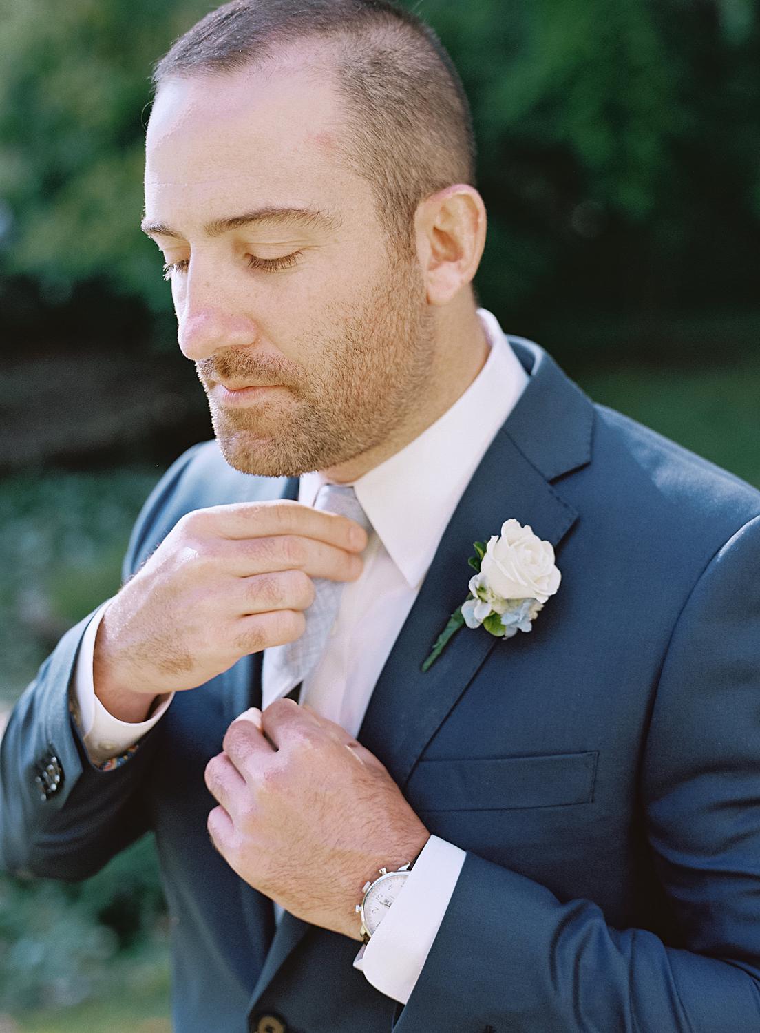 Groom adjusting his tie before his wedding at The William Paca House in Annapolis.