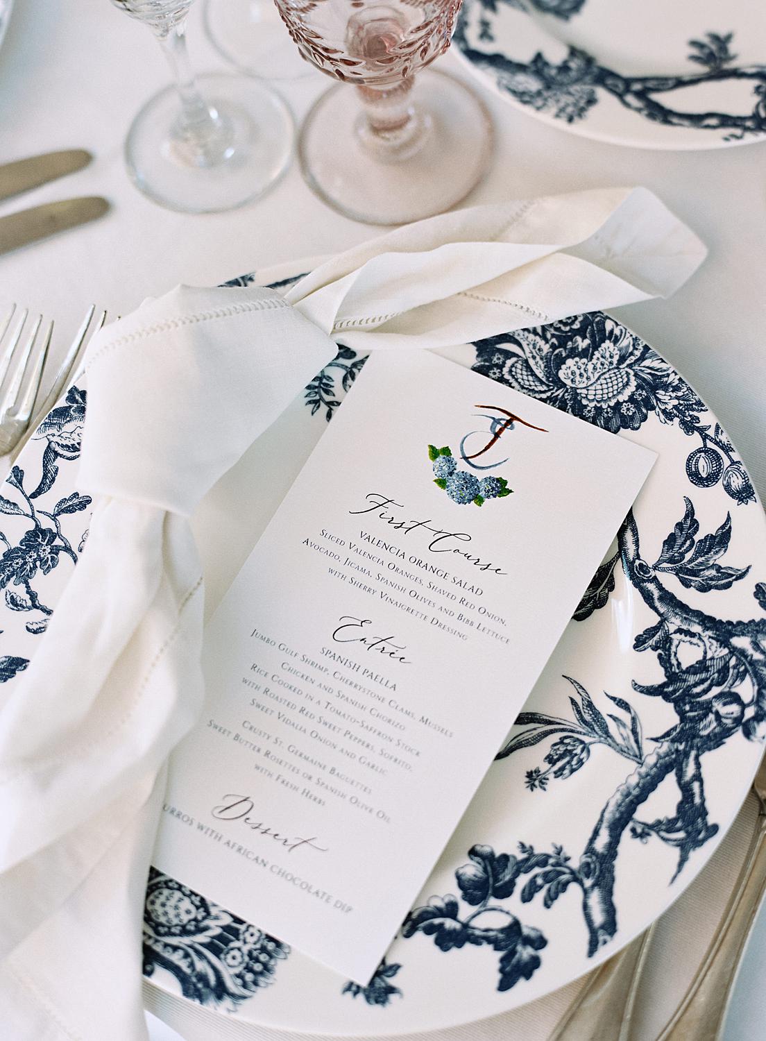 Reception detail shot of chinoiserie plate with printed menus and knotted napkin during William Paca House wedding.