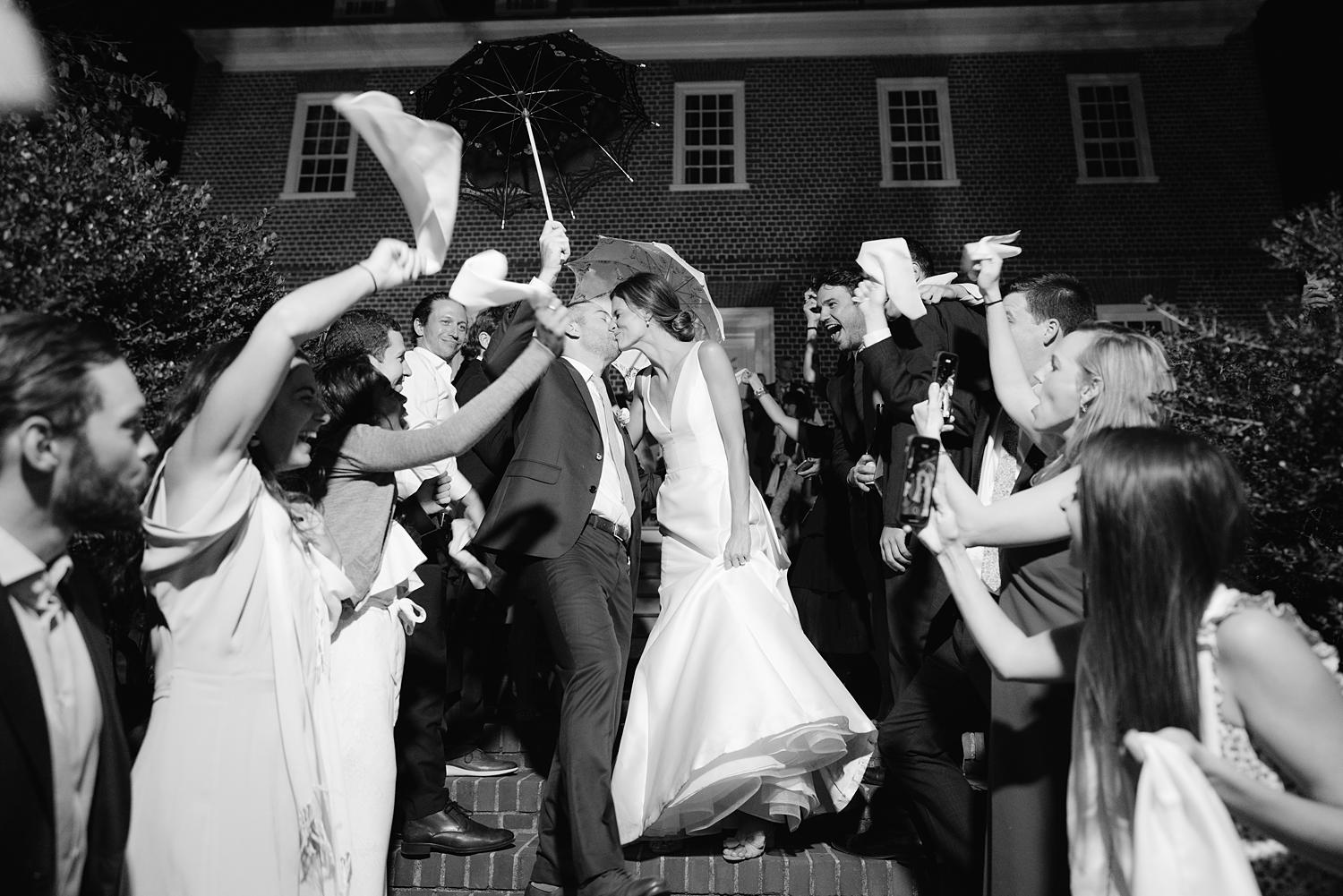 Bride and groom kissing as they exit their wedding reception at The WIlliam Paca House.